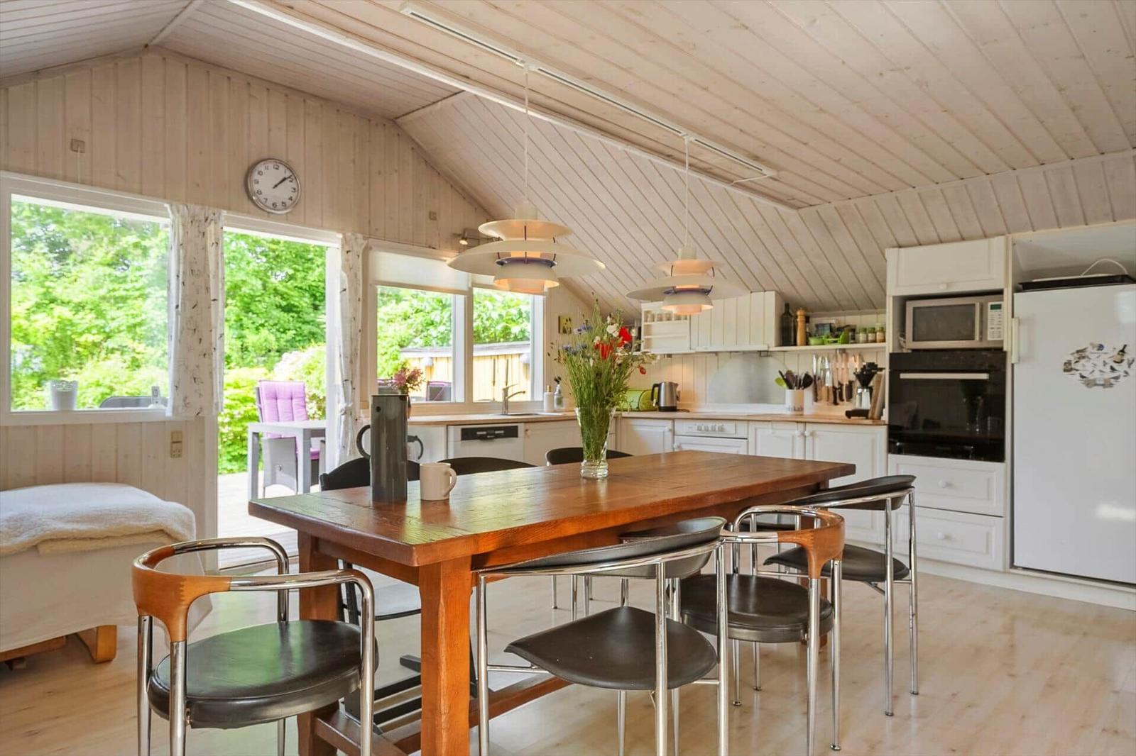 Küche mit Essbereich, Holztisch, Stühlen und Blick auf den Garten.