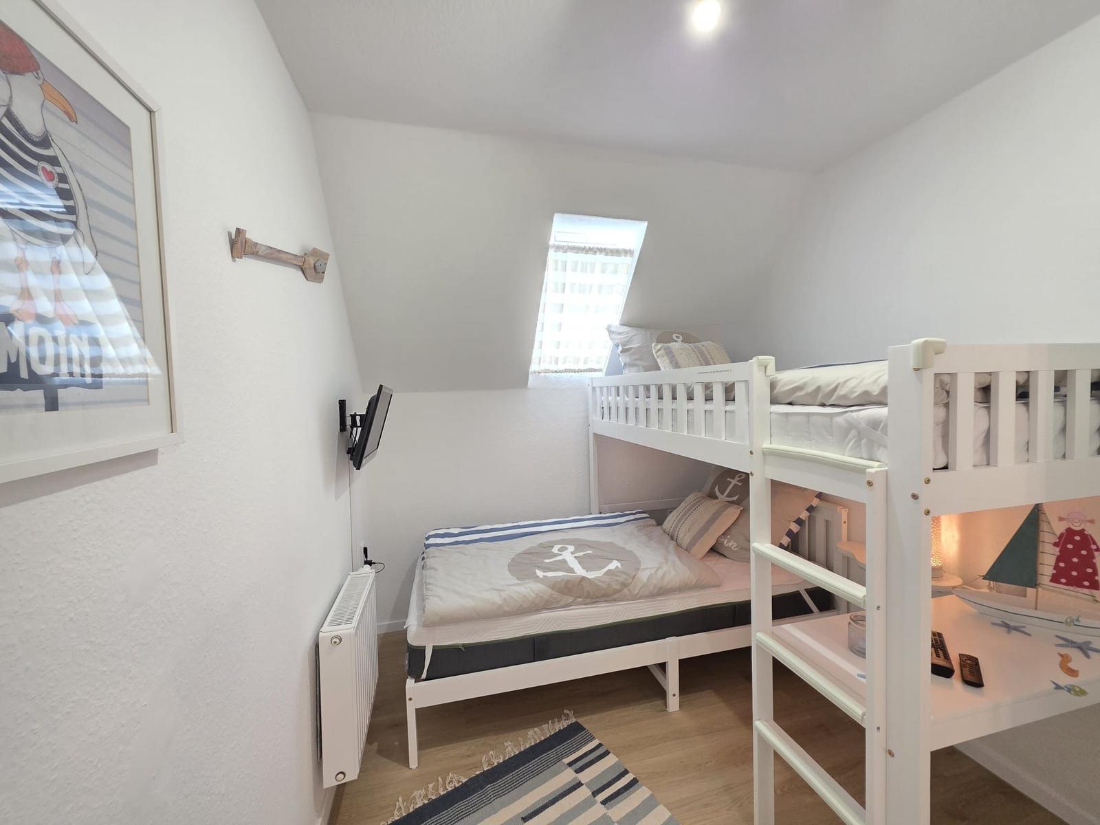 Kinderzimmer mit Doppelstockbett, Wandbild und Dachfenster.