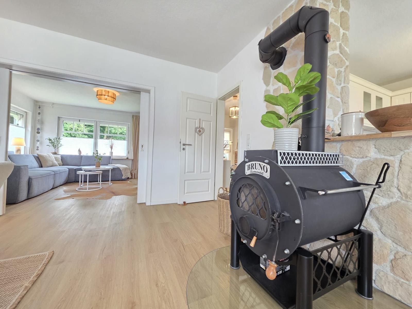 Kaminofen mit Steinwand, Wohnzimmer mit Sofa und Holzboden