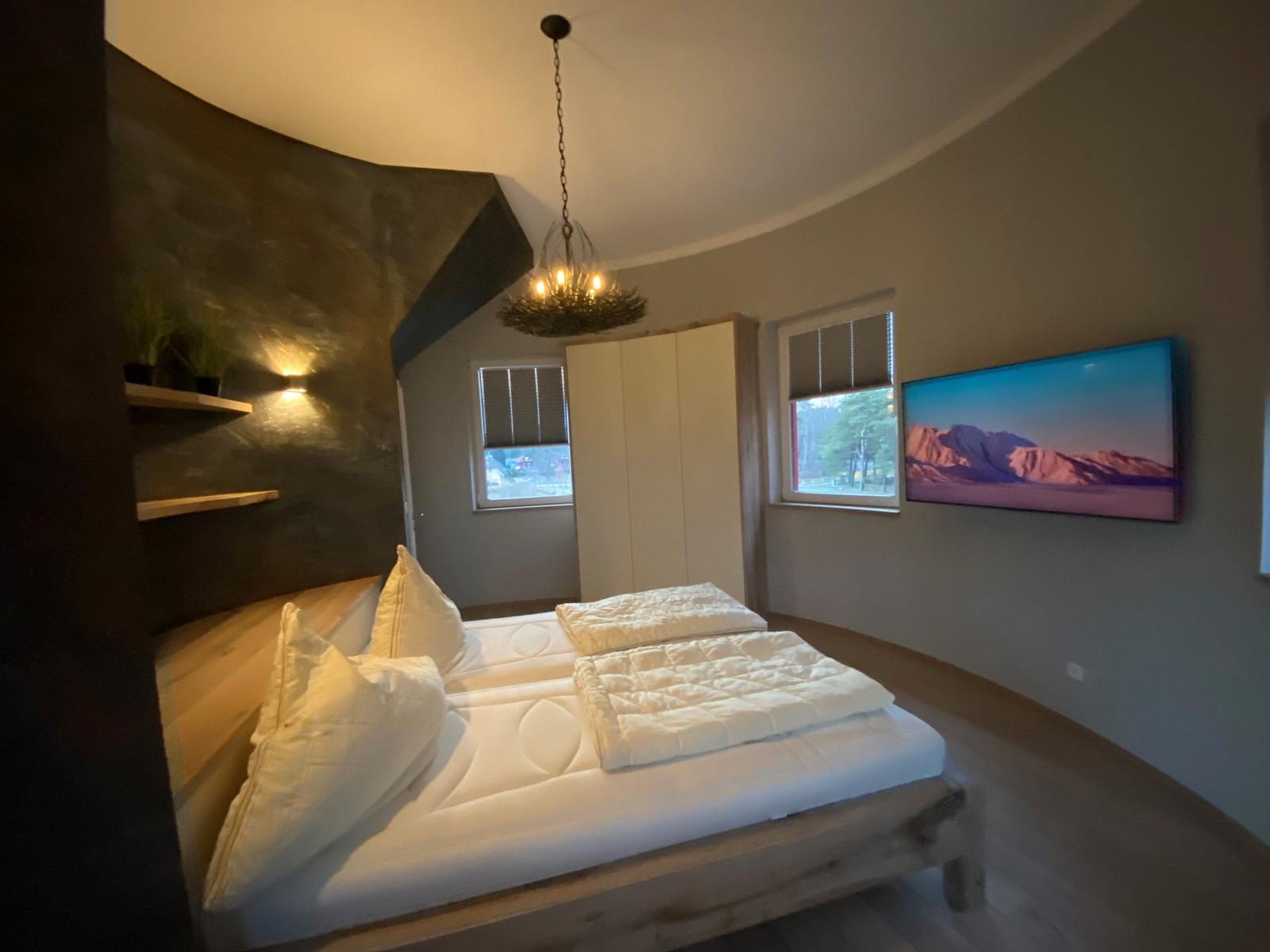 Schlafzimmer mit Bett, Fenster und Wandbild