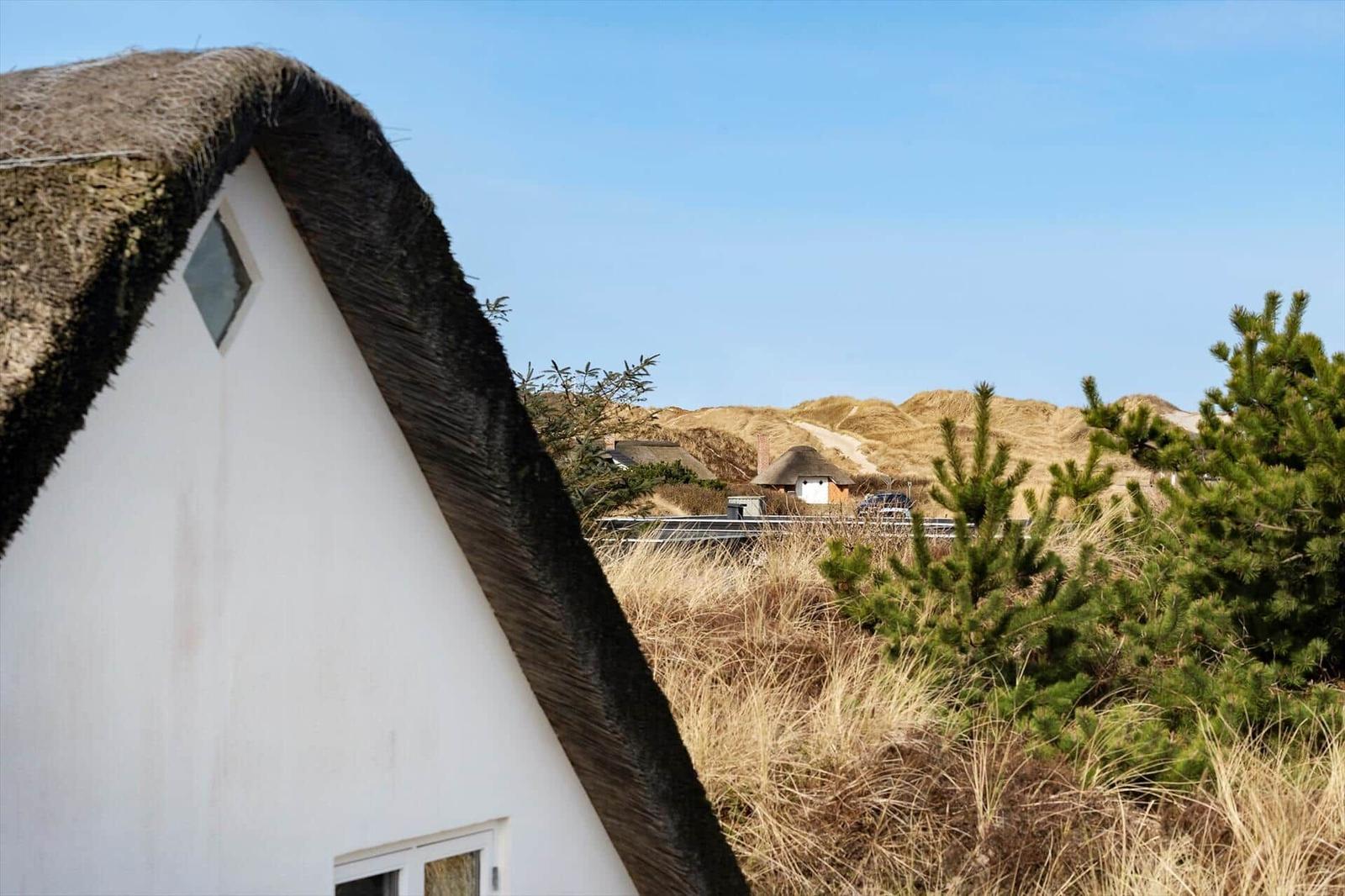 Dorfhaus mit Strohdach, Blick auf Dünen und weitere Häuser
