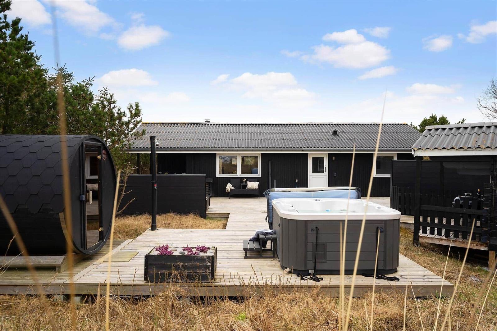 Schwarze Hütte mit Whirlpool und Terrasse im Freien