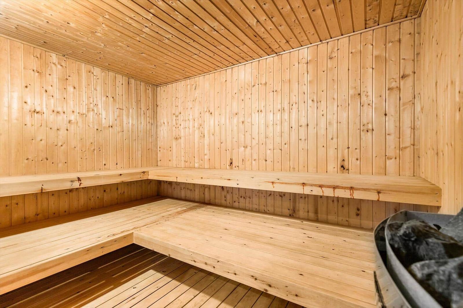 Sauna mit Holzwandverkleidung und mehreren Sitzbänken