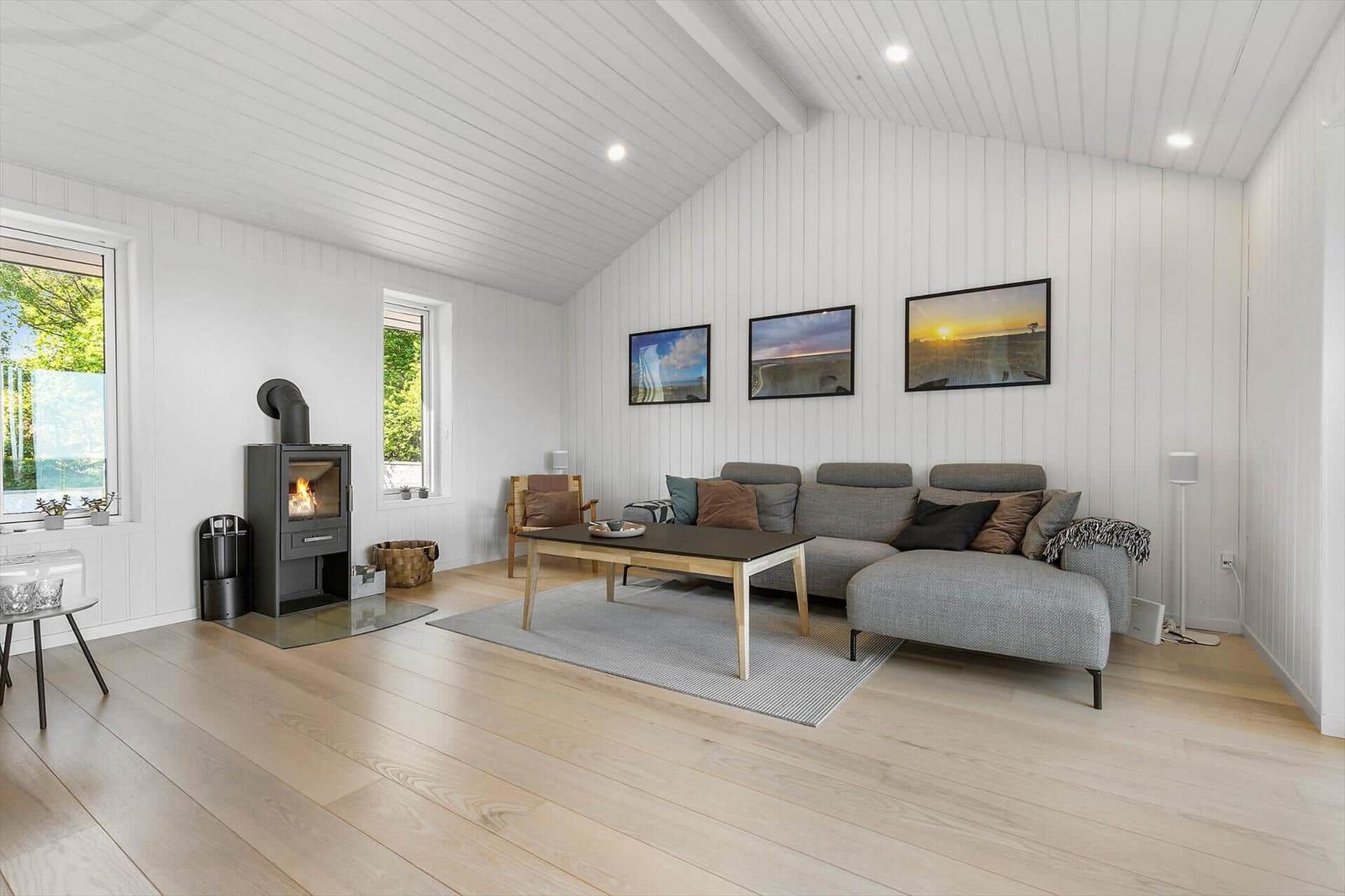 Wohnzimmer mit Kamin, Sofa und Bildern an der Wand.