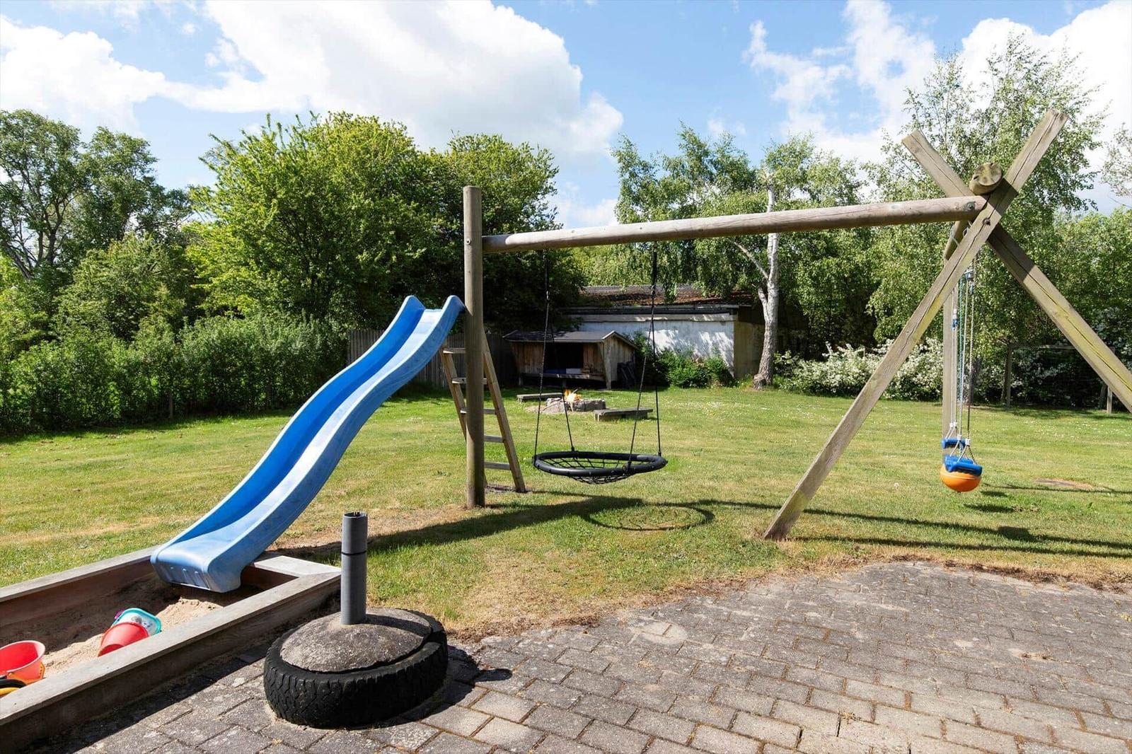 Hinterhof mit Spielplatz, Rutsche, Schaukel und Sandkasten.