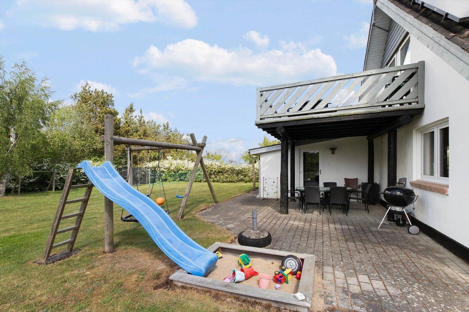 Hinterhof mit Spielplatz, Sandkasten und Terrasse mit Grill und Sitzgruppe.