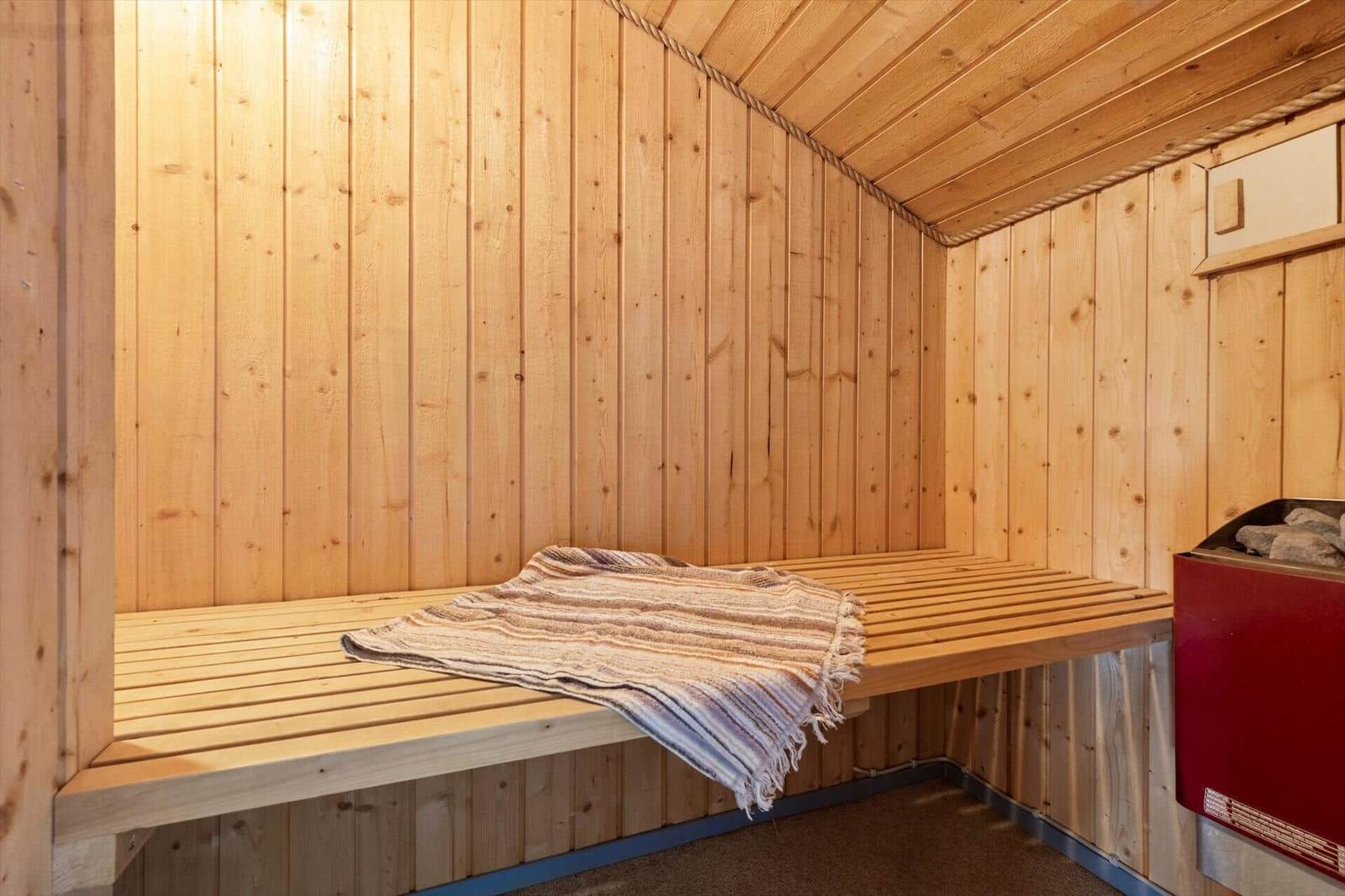 Holzsauna mit Sitzbank und Deckenheizung. Eine Deckenheizung und eine Deckenheizung.