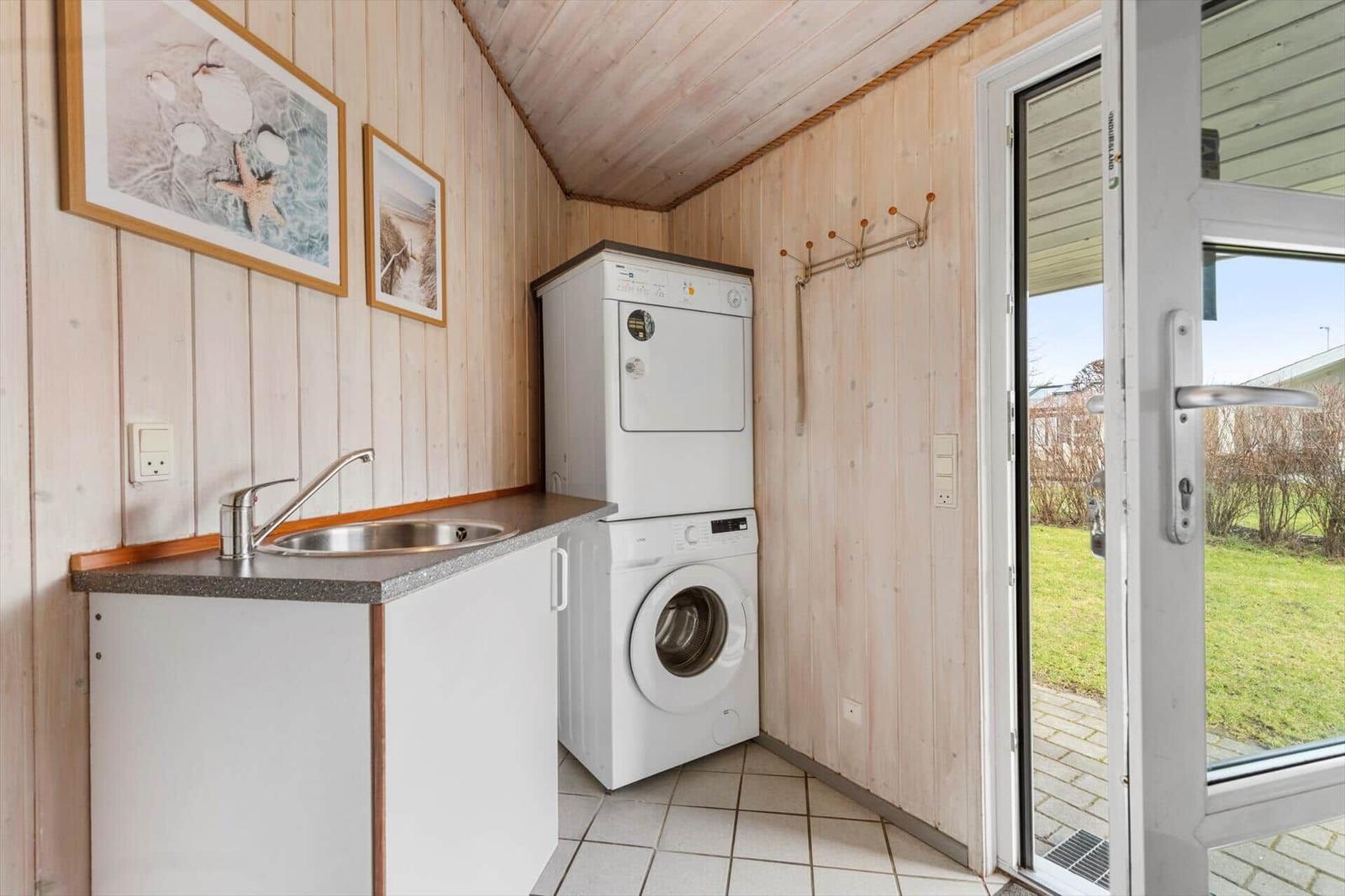Wohnung mit Waschmaschine und Trockner, Küchenzeile und Blick auf den Garten.