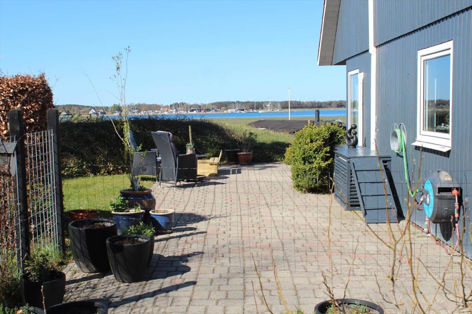Terrasse mit Sitzgelegenheit und Blick auf das Wasser.