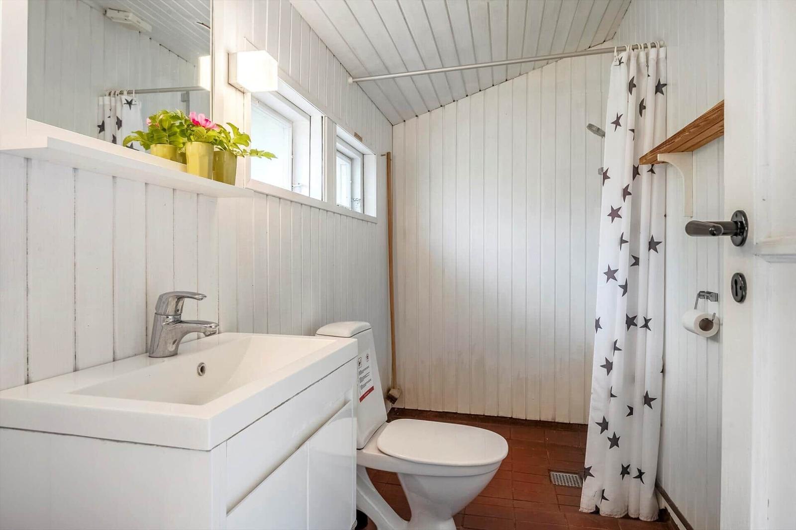 Badezimmer mit Waschbecken, Toilette und Dusche mit Sternen-Badewannenvorhang.