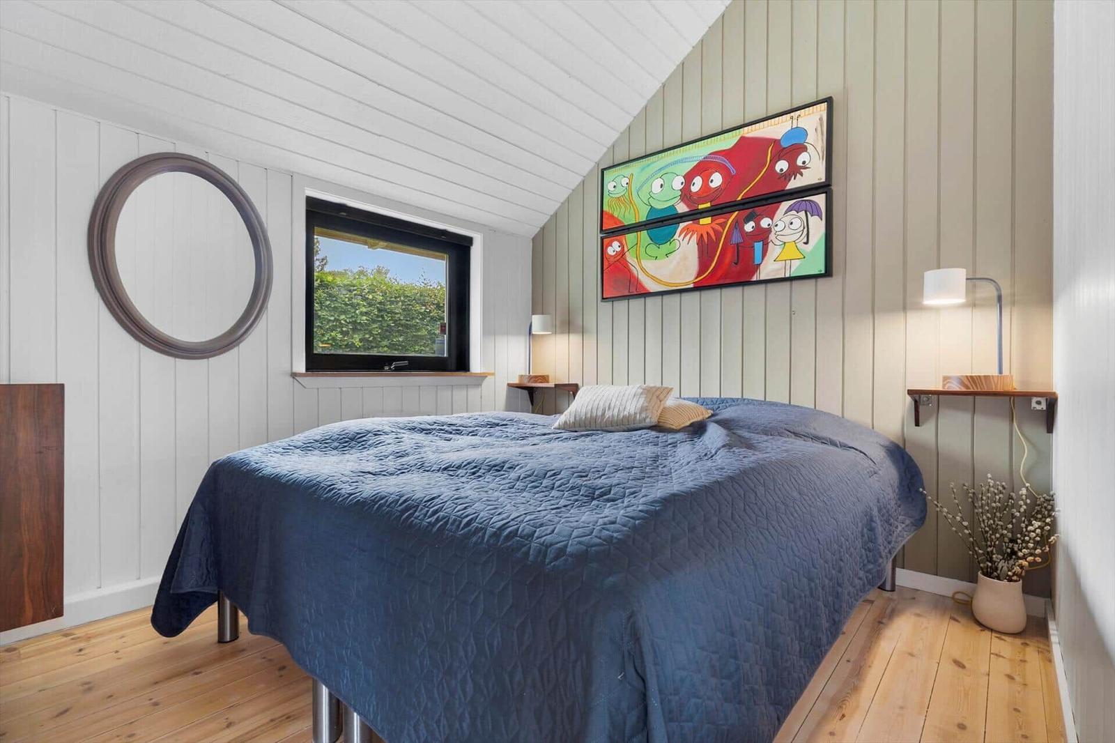 Schlafzimmer mit Bett, Fenster und Wandbild