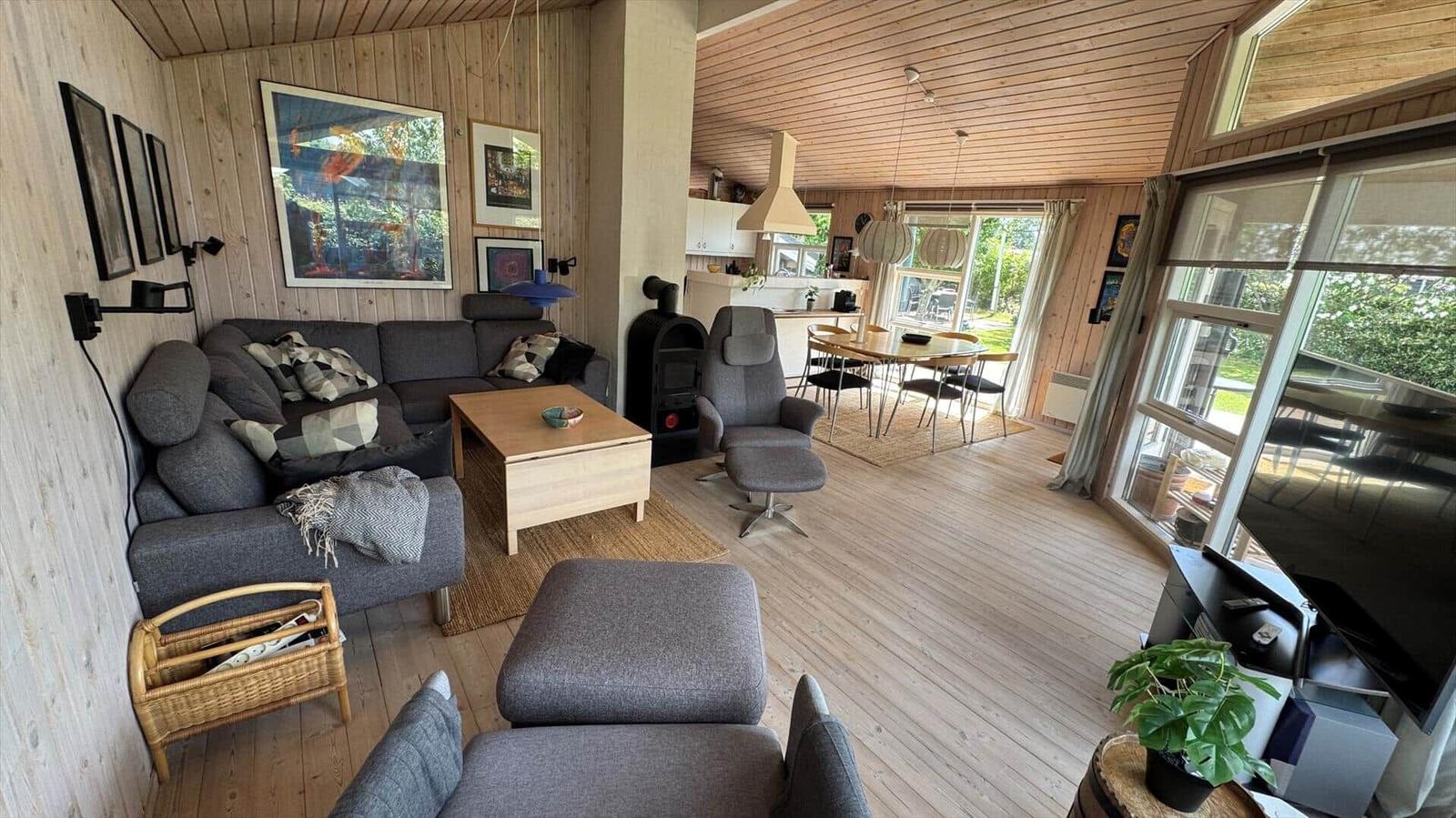 Wohnzimmer mit Sofa, Couchtisch und Blick in die Küche.