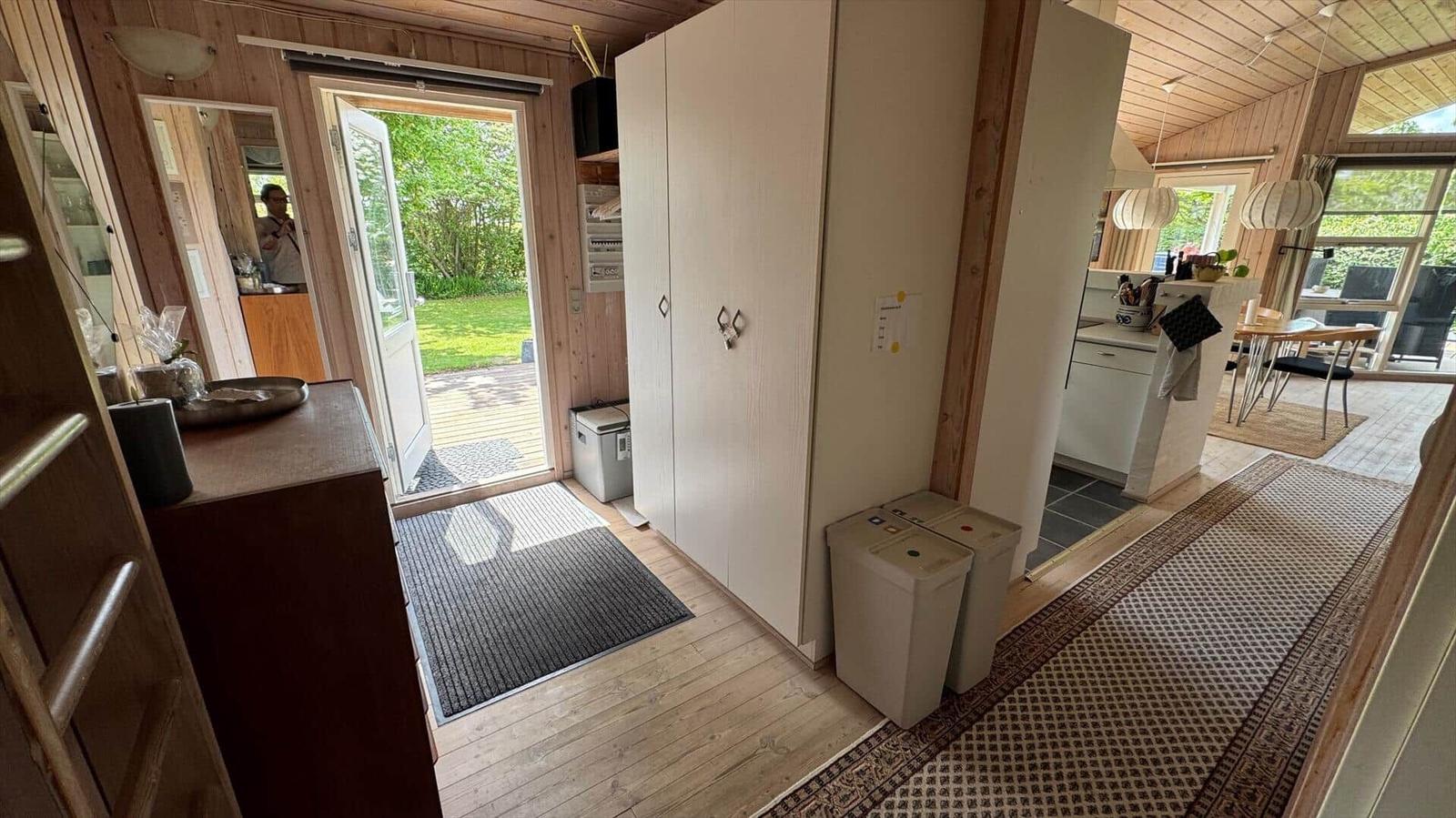Eingangsbereich mit Schrank, Tür zum Garten und Blick in Küche und Essbereich.