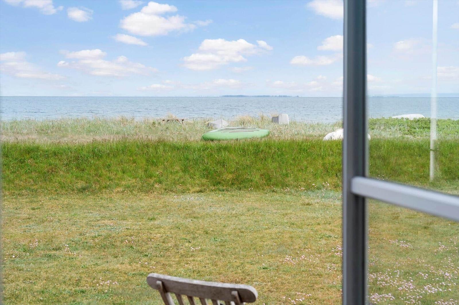 Von innen betrachtet, zeigt das Bild einen Blick auf eine grüne Wiese und das Meer.