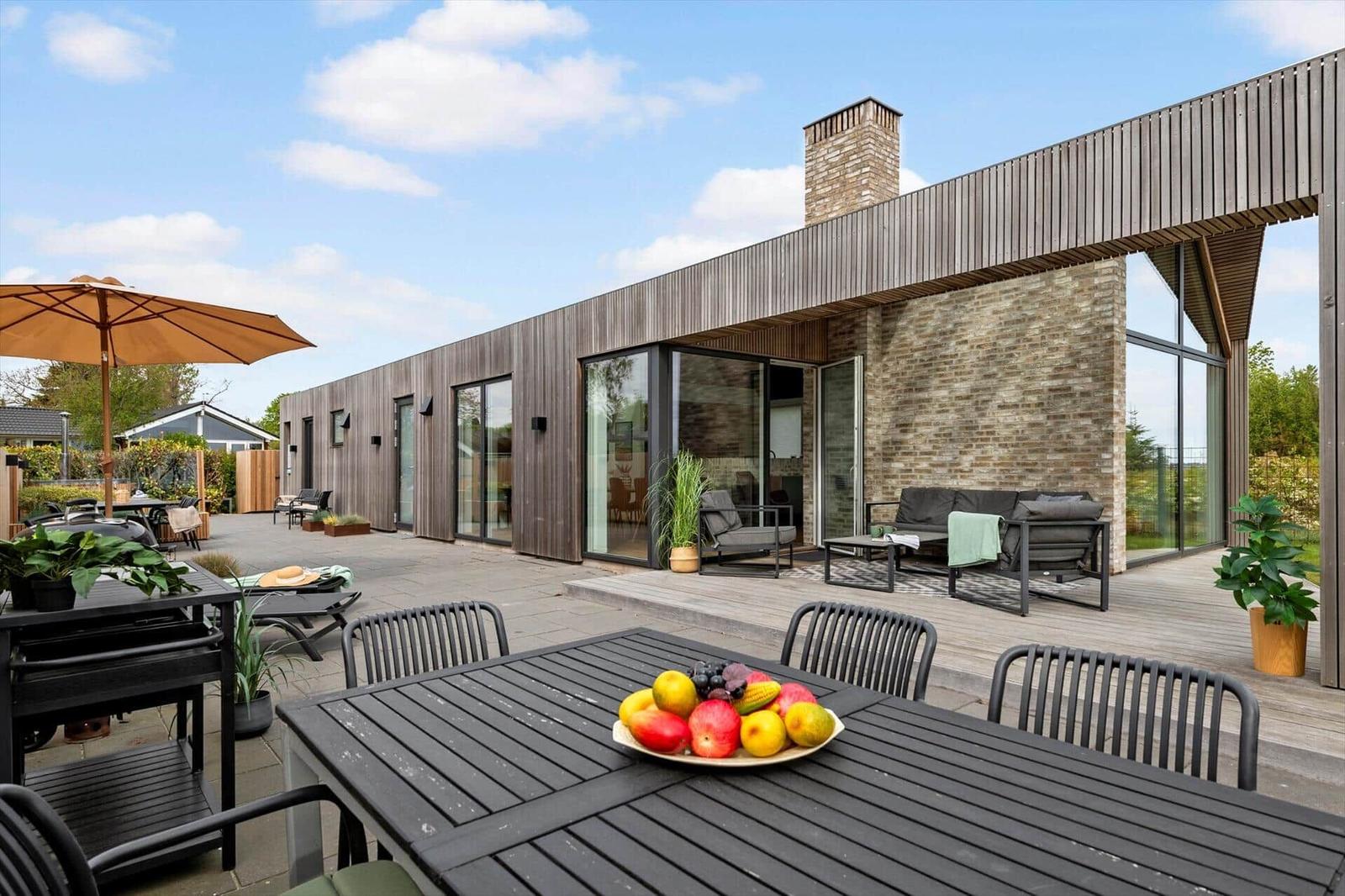 Moderne Villa mit großem Außenbereich, Terrasse, Sitzgelegenheiten und Grillplatz.