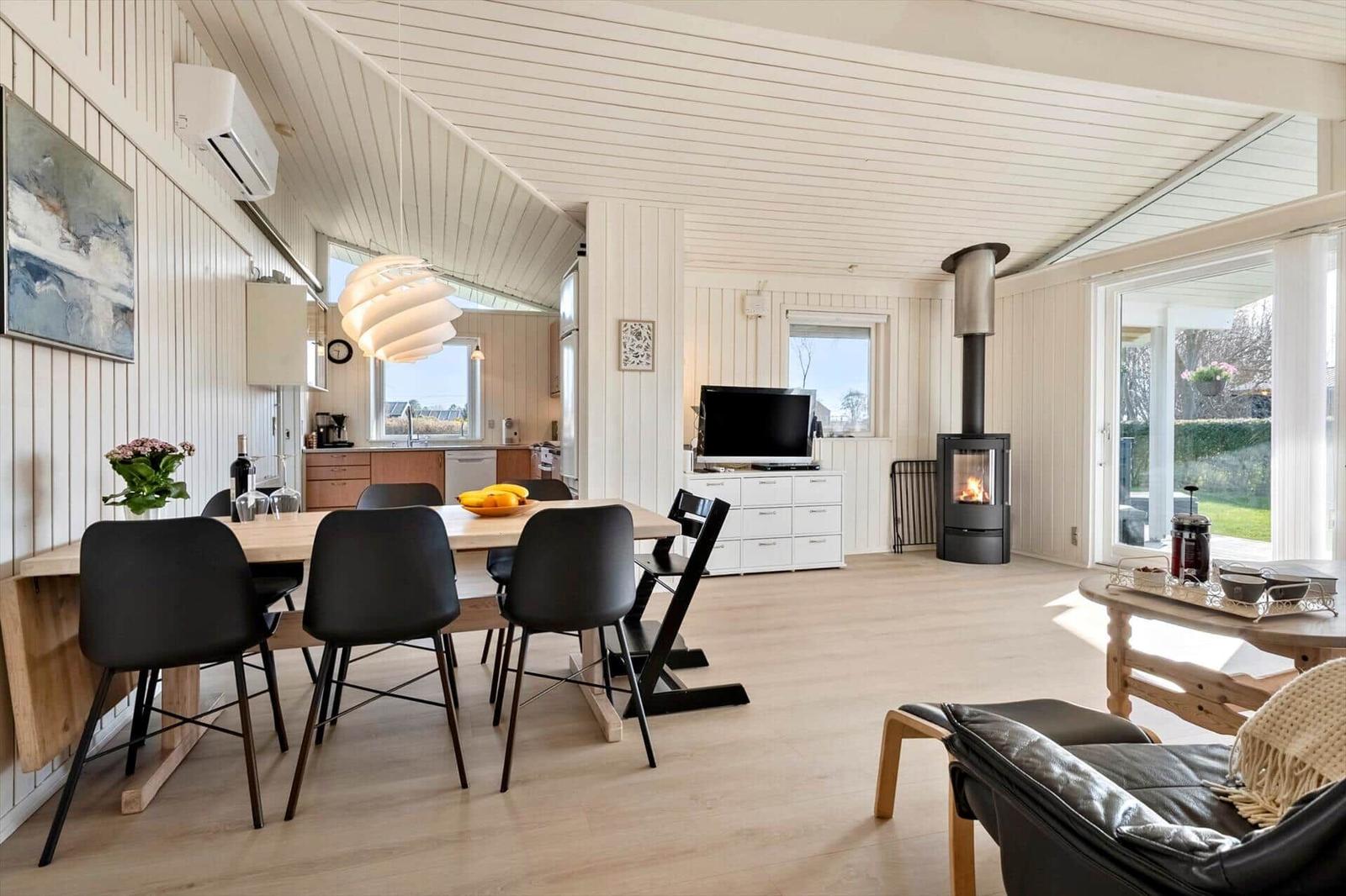 Living and dining area with wood stove, dining table, and TV.