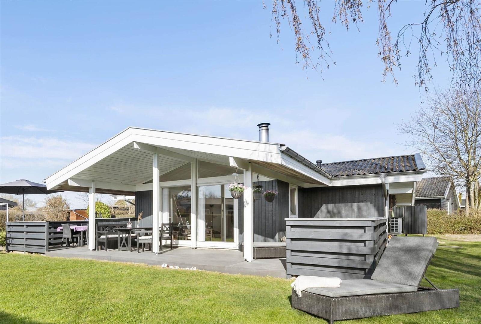 Modern villa with terrace, garden furniture, and barbecue area. Outdoor seating available.