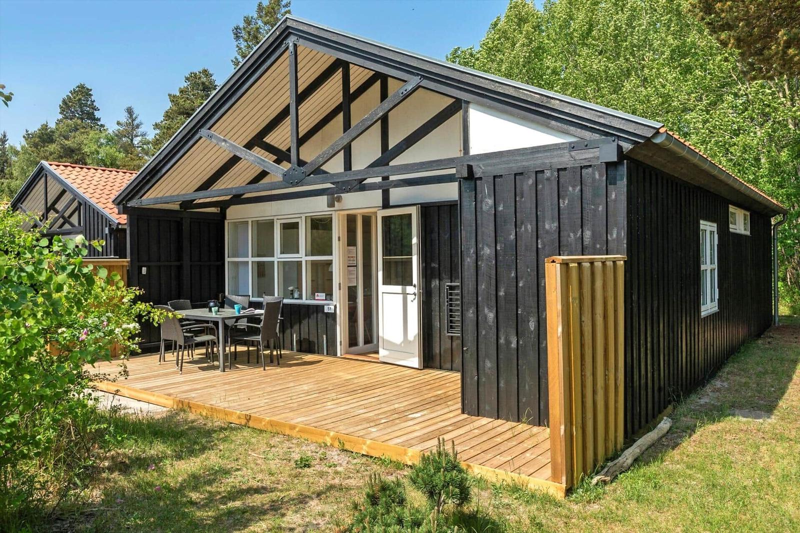 Holzhaus mit Terrasse und Sitzgruppe im Grünen
