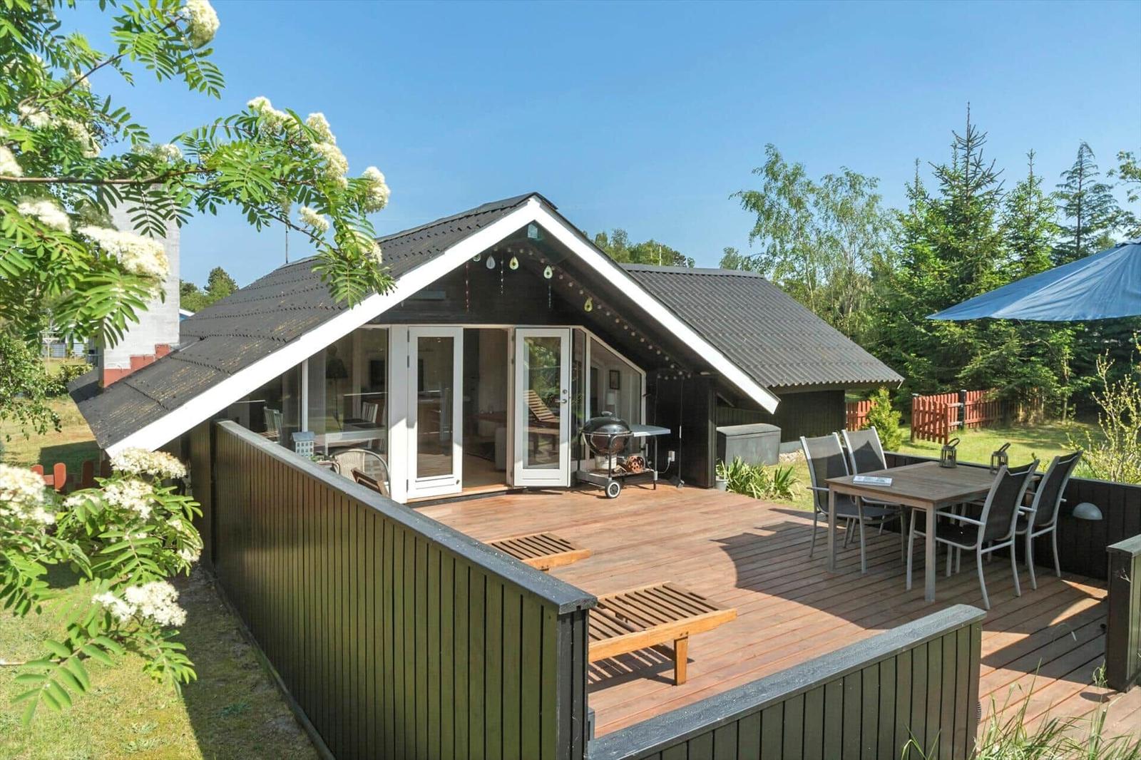 House with terrace, grill, and seating in the garden.