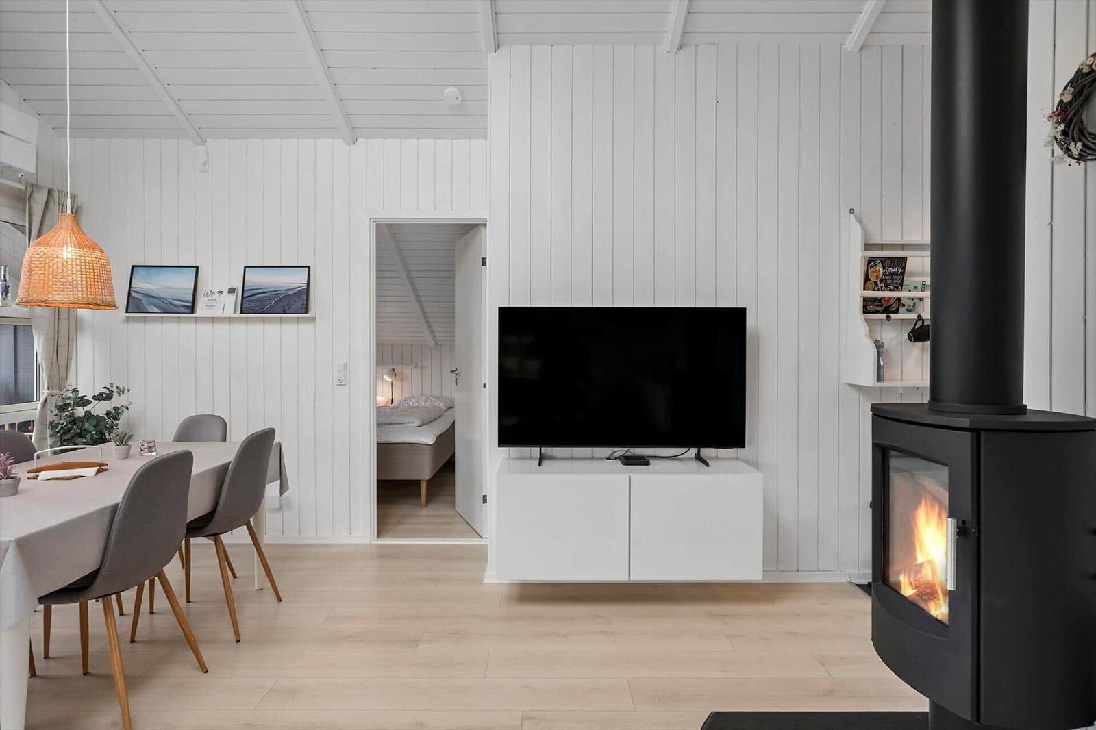 Wohnzimmer mit Kamin, TV und Essbereich. Durchgang zur Schlafzimmer.