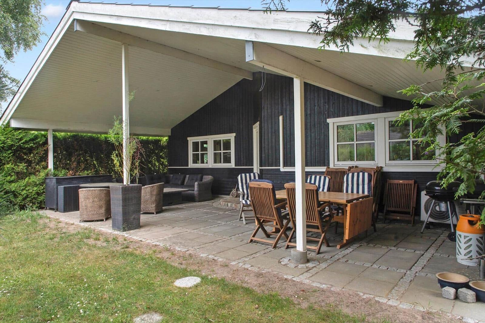 Terrasse mit Sitzgruppe, Tisch und Stühlen unter Dach