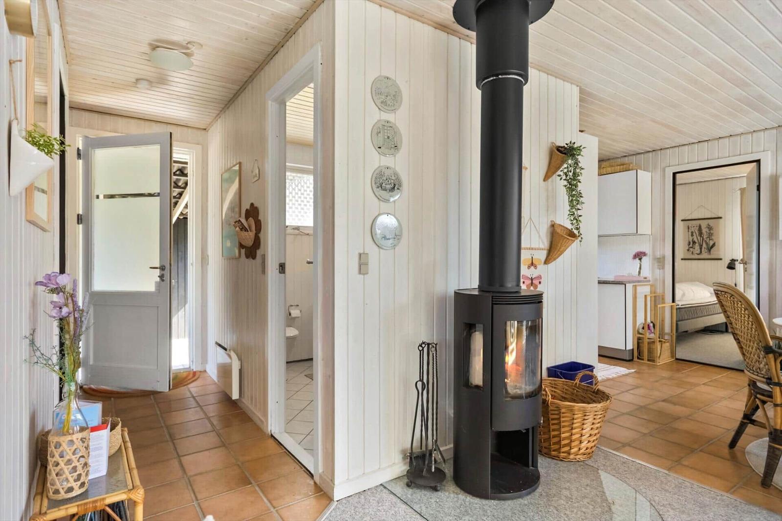 Haus mit Kamin, Flur und Blick in Schlafzimmer und Bad.