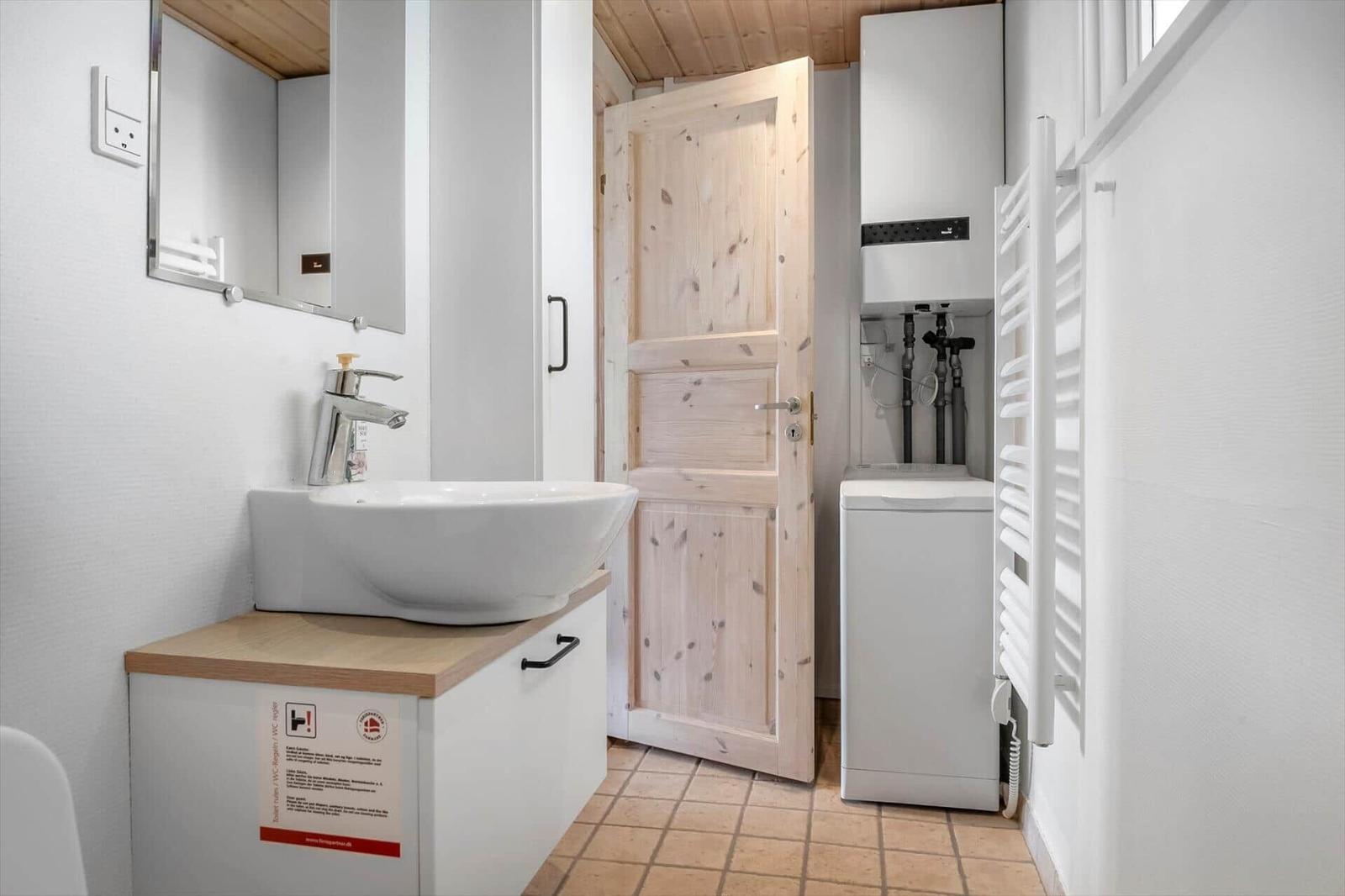 Badezimmer mit Waschbecken, Spiegel und Heizkörper