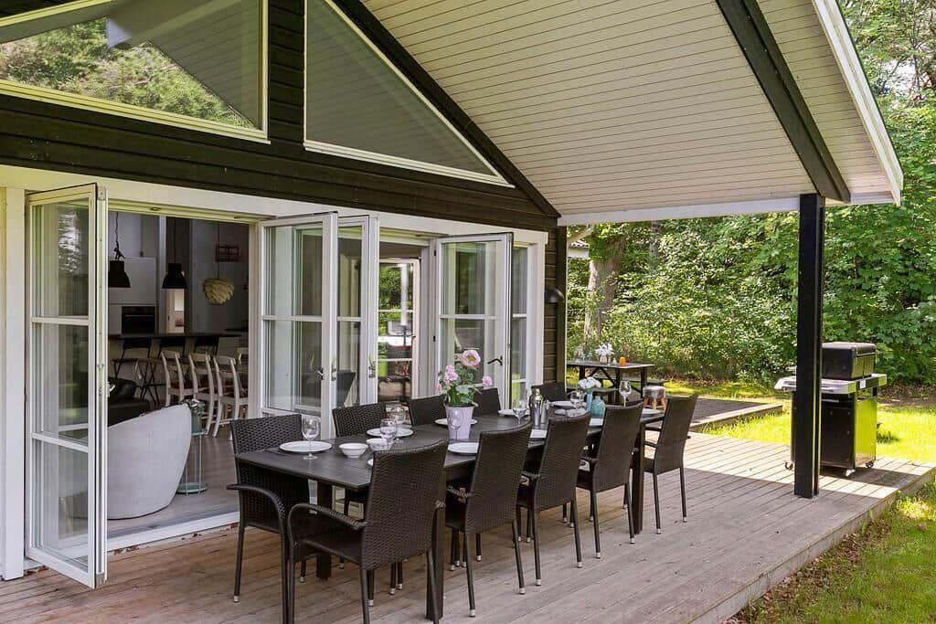 Terrasse mit Tisch und Stühlen, Grill und Blick in die Küche.