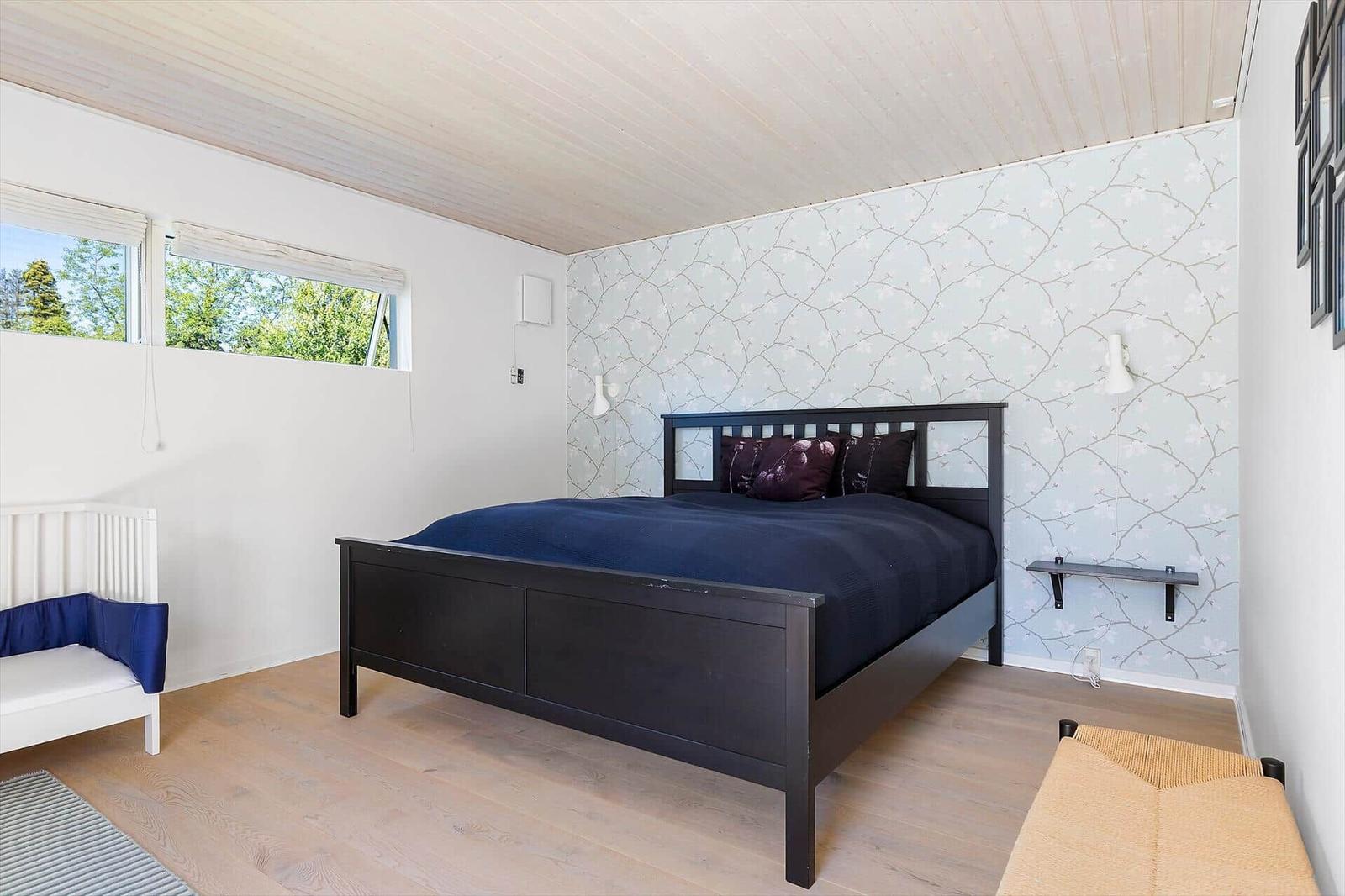 Schlafzimmer mit Bett, Fenster und Tapete an der Wand