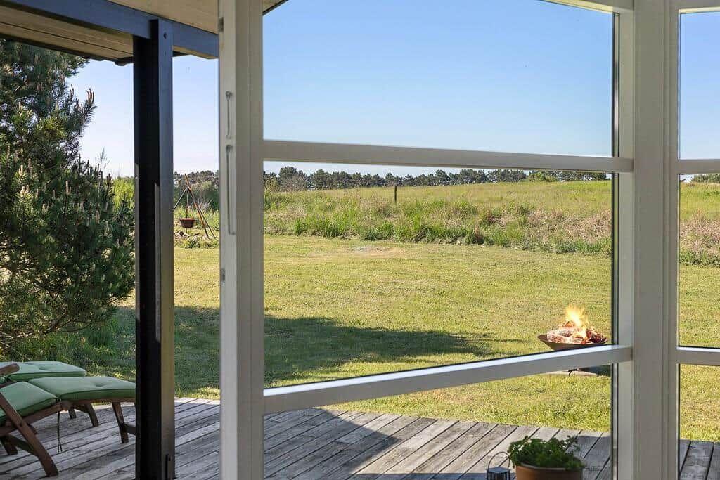Terrasse mit Blick auf Grünfläche und brennendem Feuerbecken.