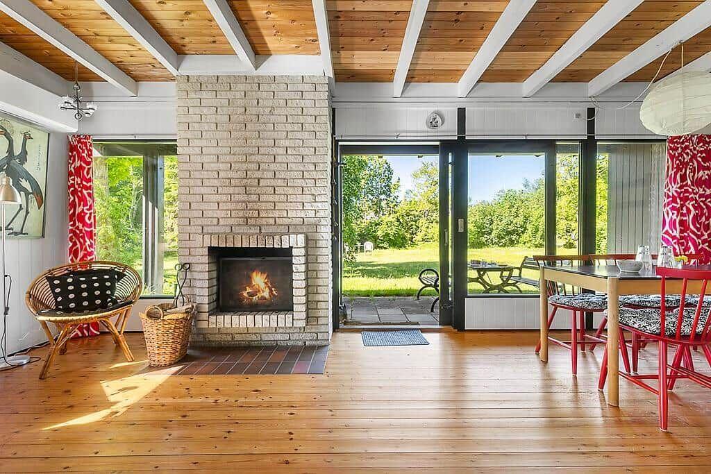 Wohn- und Essbereich mit Kamin, Holzboden und Blick auf Garten