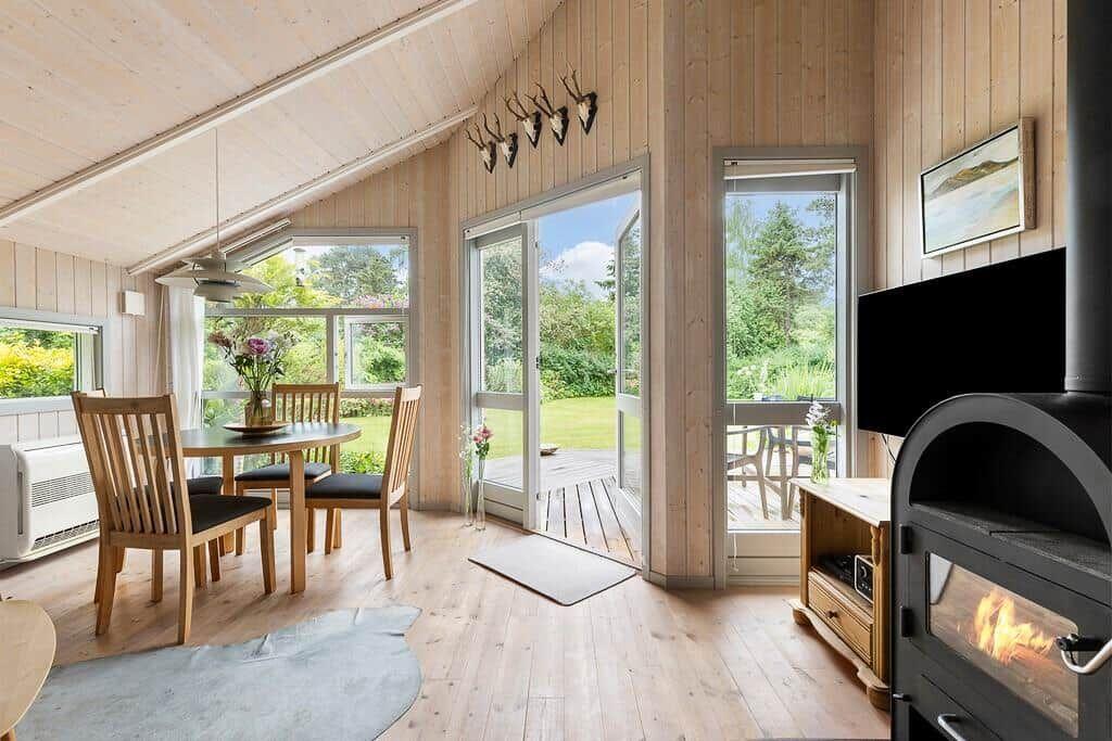 Wohnraum mit Esstisch, Kamin und Blick auf Garten