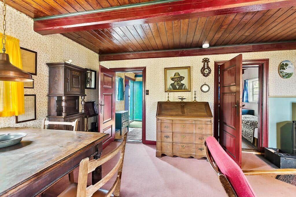 Haus mit Essbereich, Schreibtisch und Schlafzimmer. Holzdecke und antike Möbel.