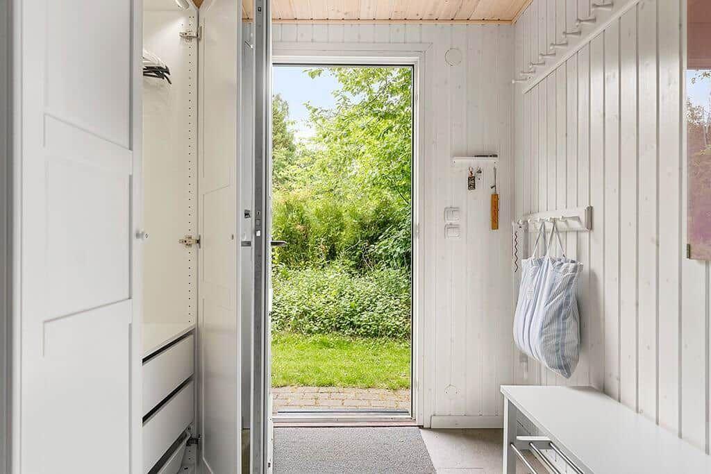 Helle Eingangshalle mit Schuhschrank und Blick auf grünen Garten