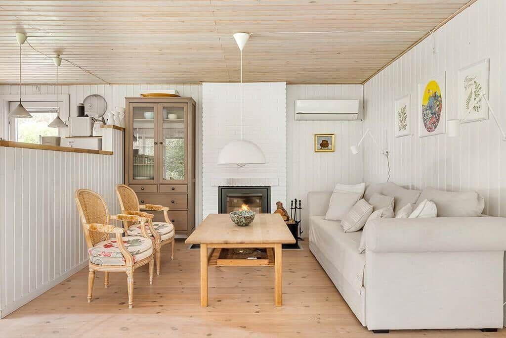 Wohnzimmer mit Sofa, Tisch, Stühlen und Kamin