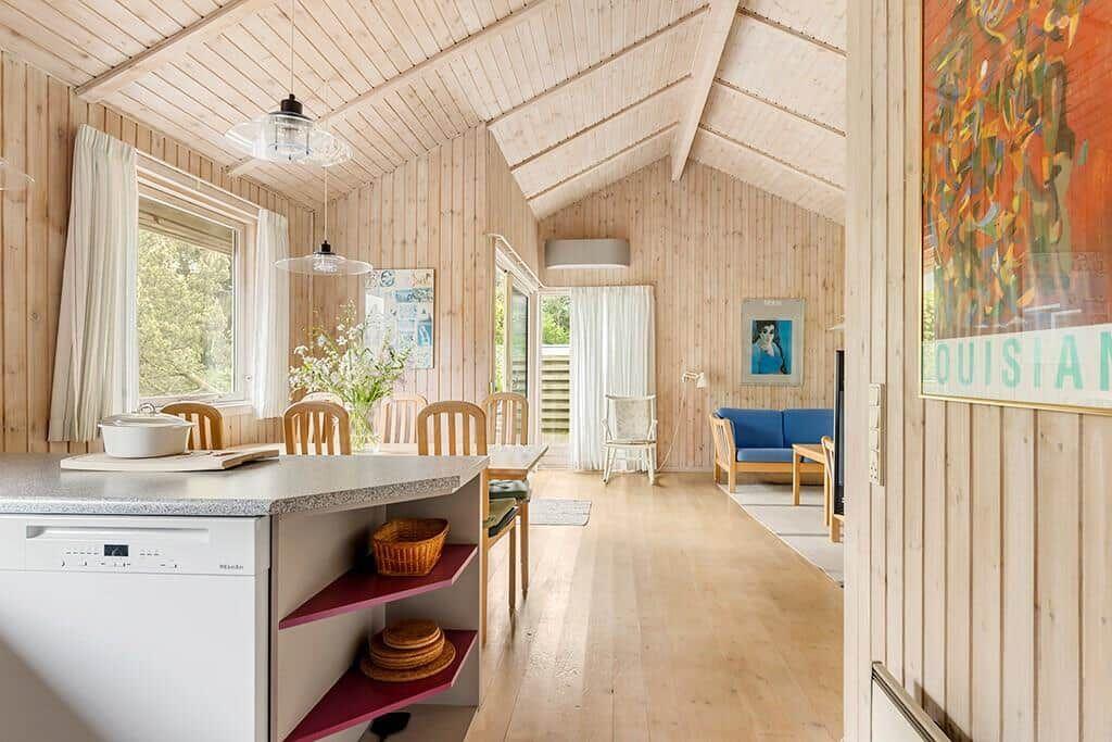 Küche mit Essbereich und Wohnzimmer mit Holzwand und Fenster