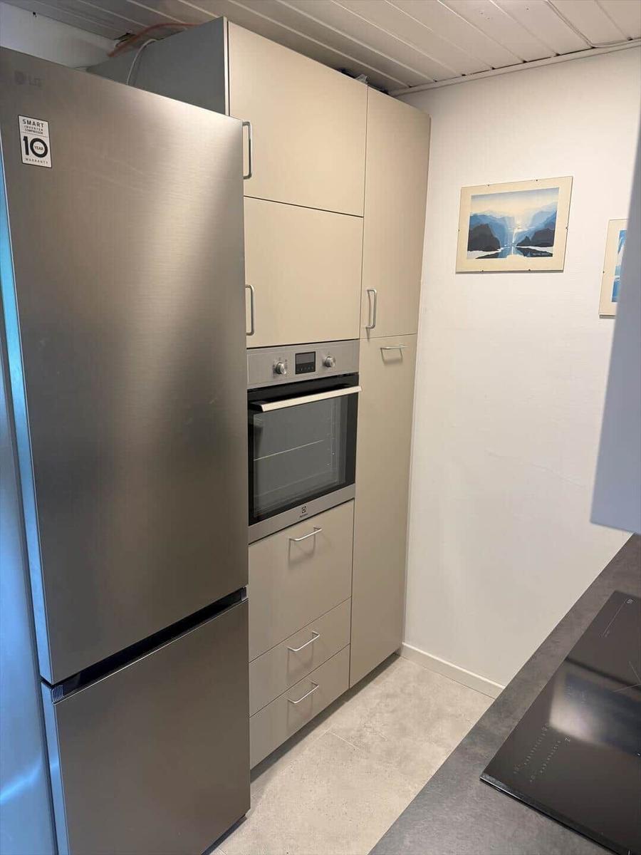 Küche mit Kühlschrank, Einbauherd und Schränken