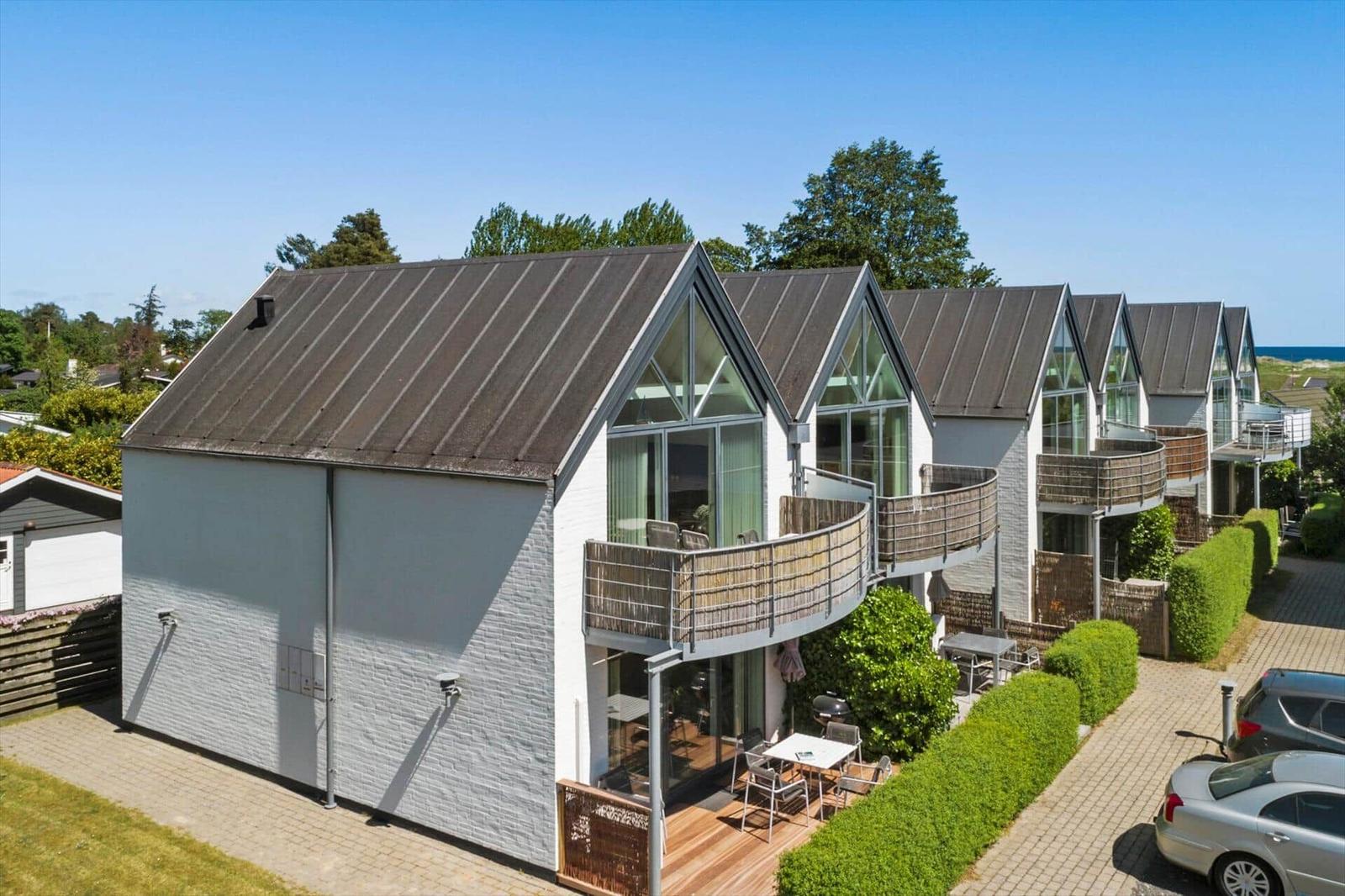 Moderne Ferienwohnungen mit Balkonen und großzügigen Fenstern an der Küste.