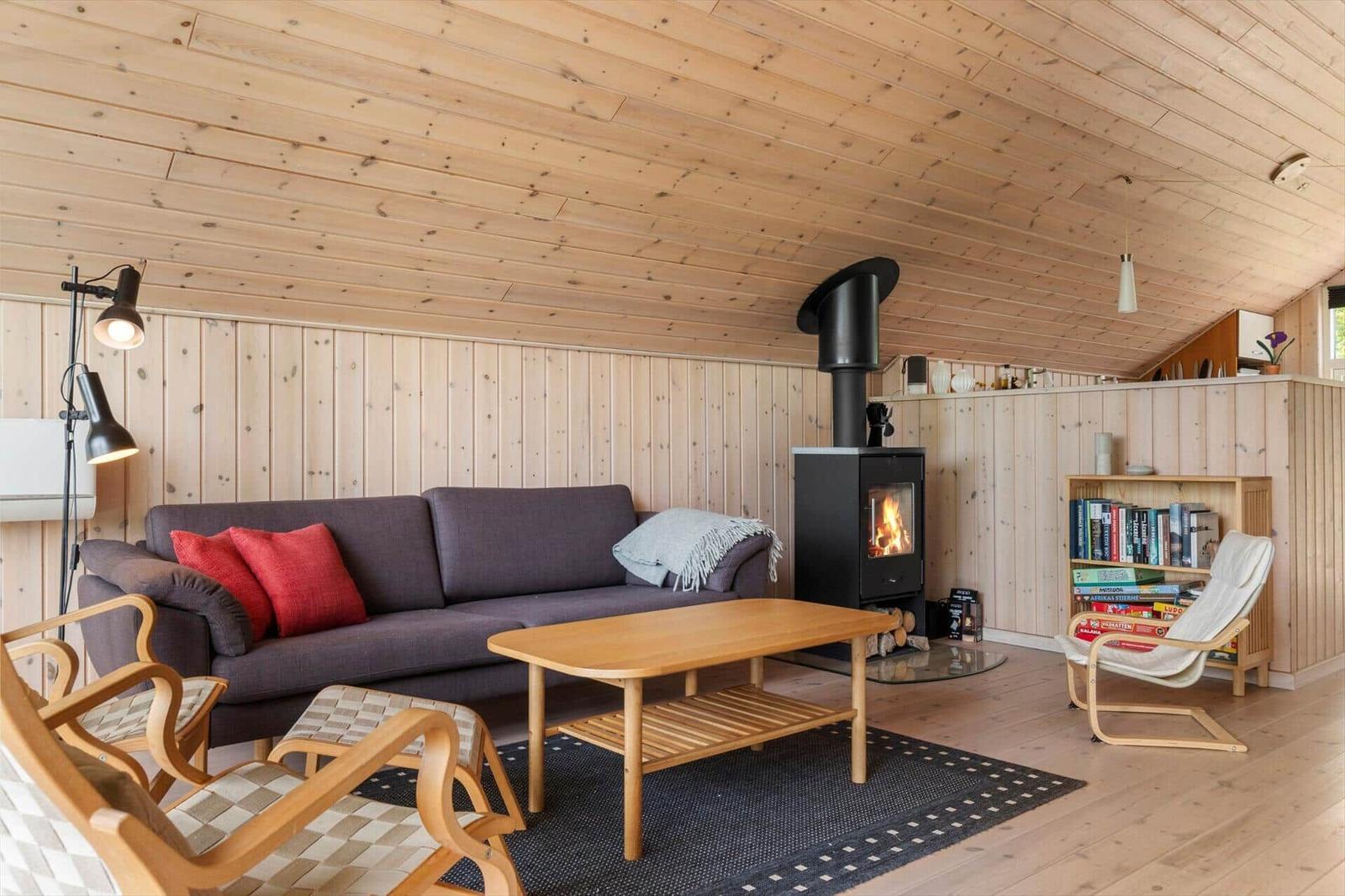 Wohnzimmer mit Sofa, Kamin und Holzmöbeln.