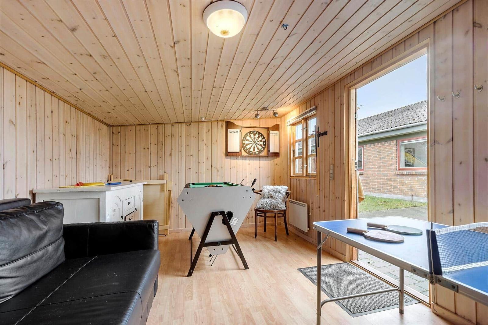 Laundry room with washing machine, dryer, and brick wall with window.