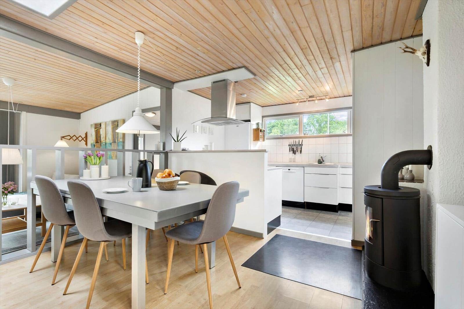 Dining area with table, chairs, and view into the kitchen.