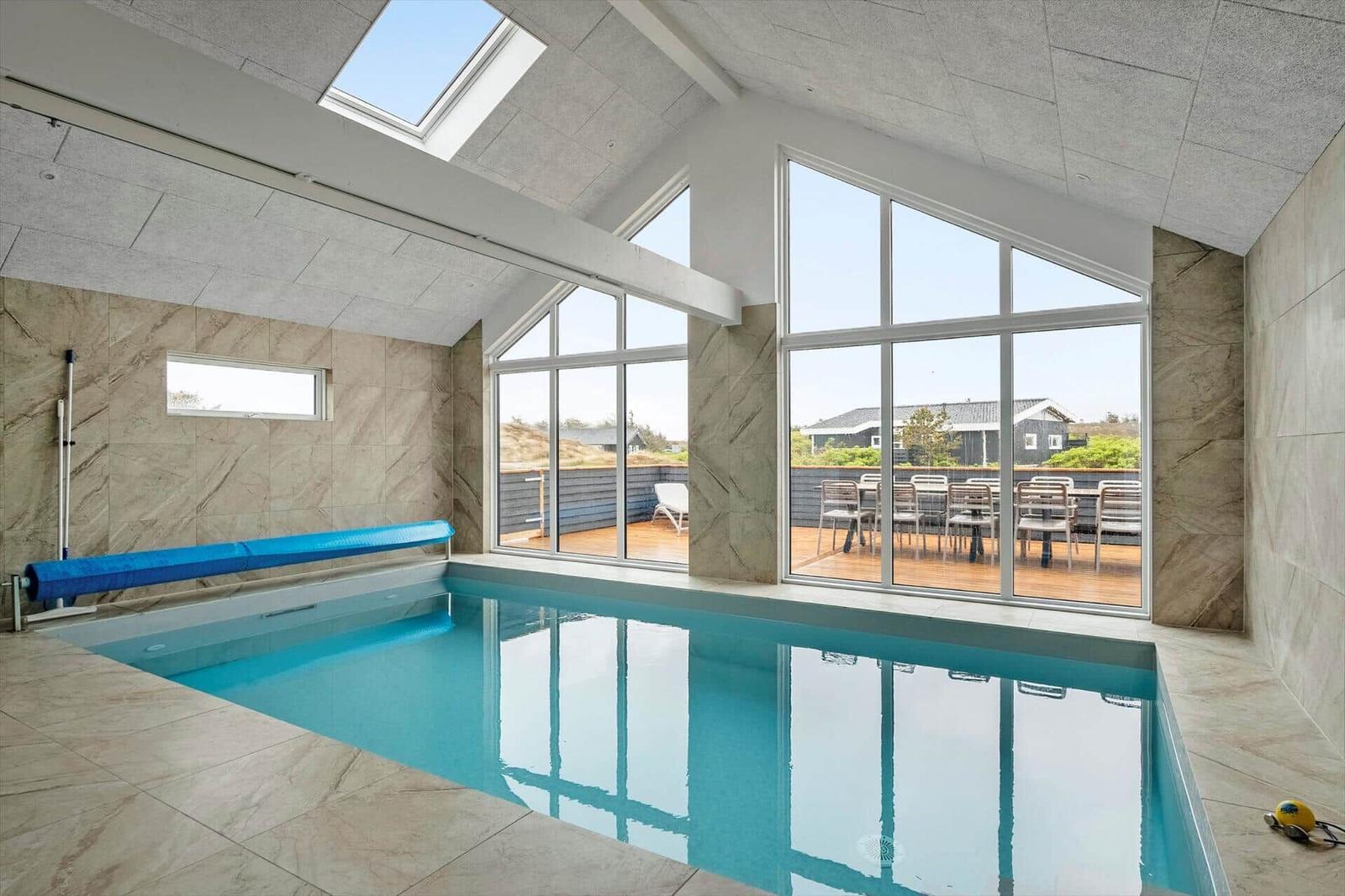 Innenpool mit großem Fensterblick auf Terrasse und Garten