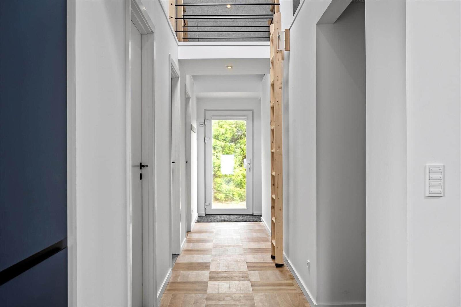 Flur mit Holzfußboden, Treppe und Tür zum Garten