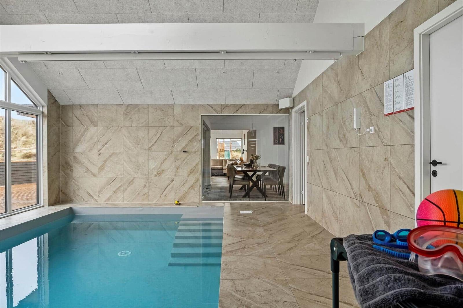Innenpool mit Steinwand und Blick in das Esszimmer