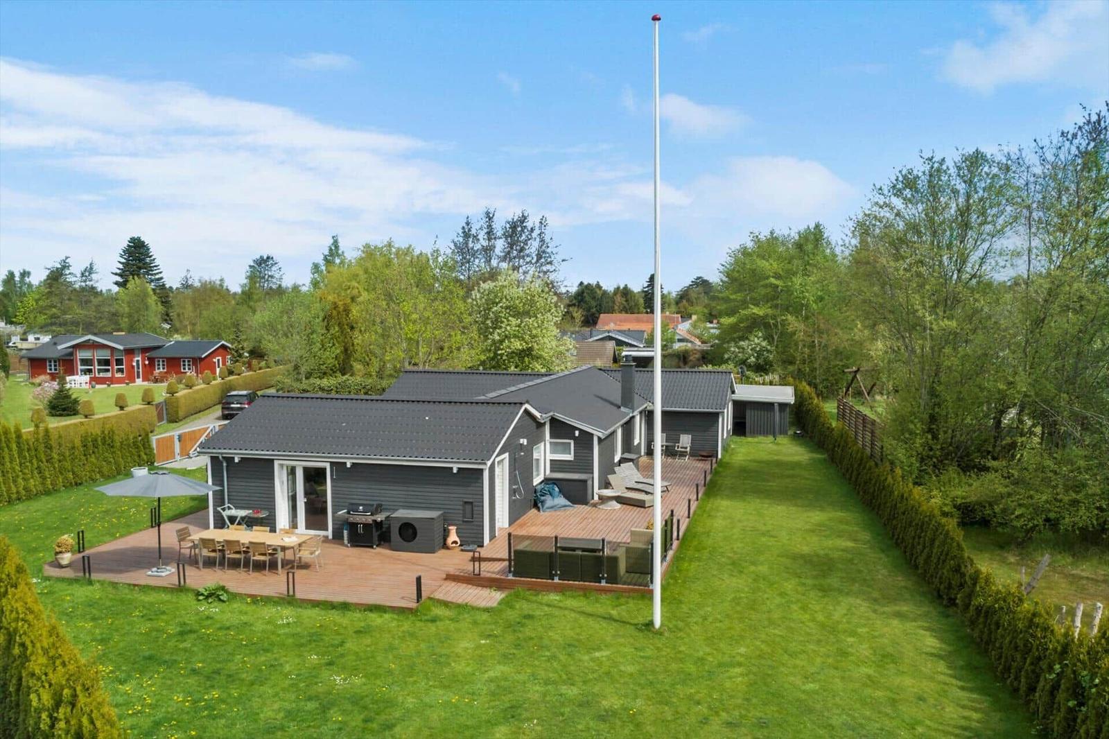 Moderne Villa mit großem Garten, Terrasse und Grillplatz. Blick auf umliegende Häuser.