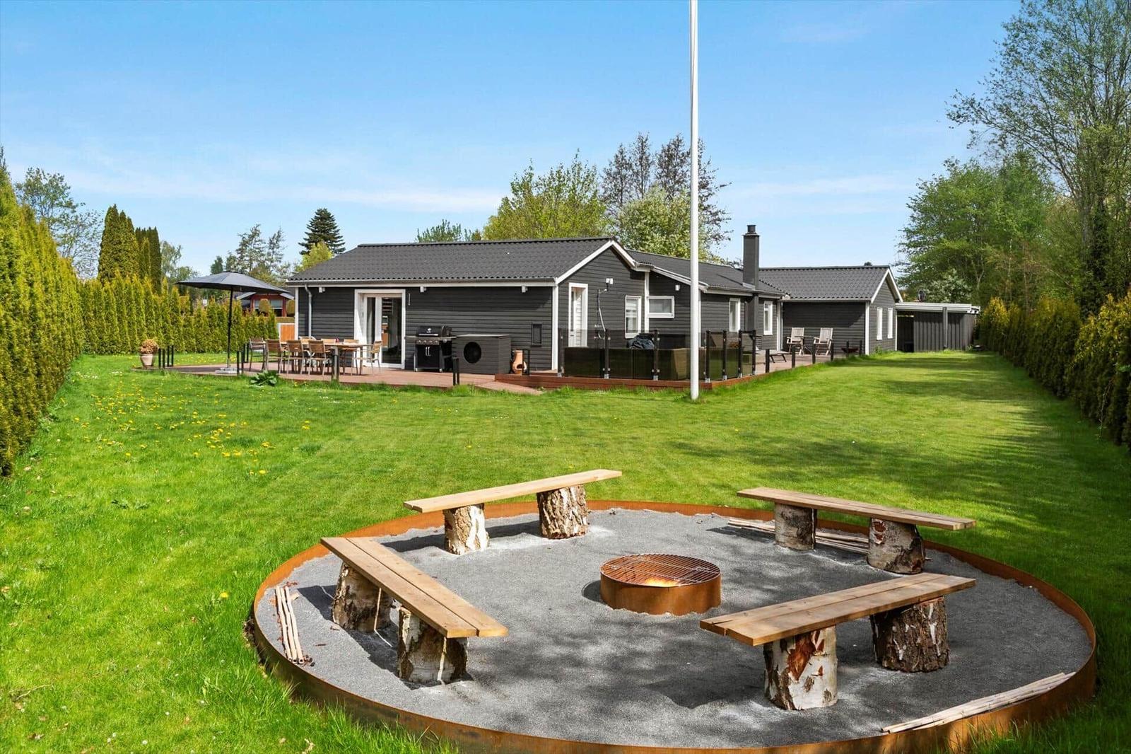 Haus mit großem Garten, Feuerkorb und Sitzgelegenheiten.