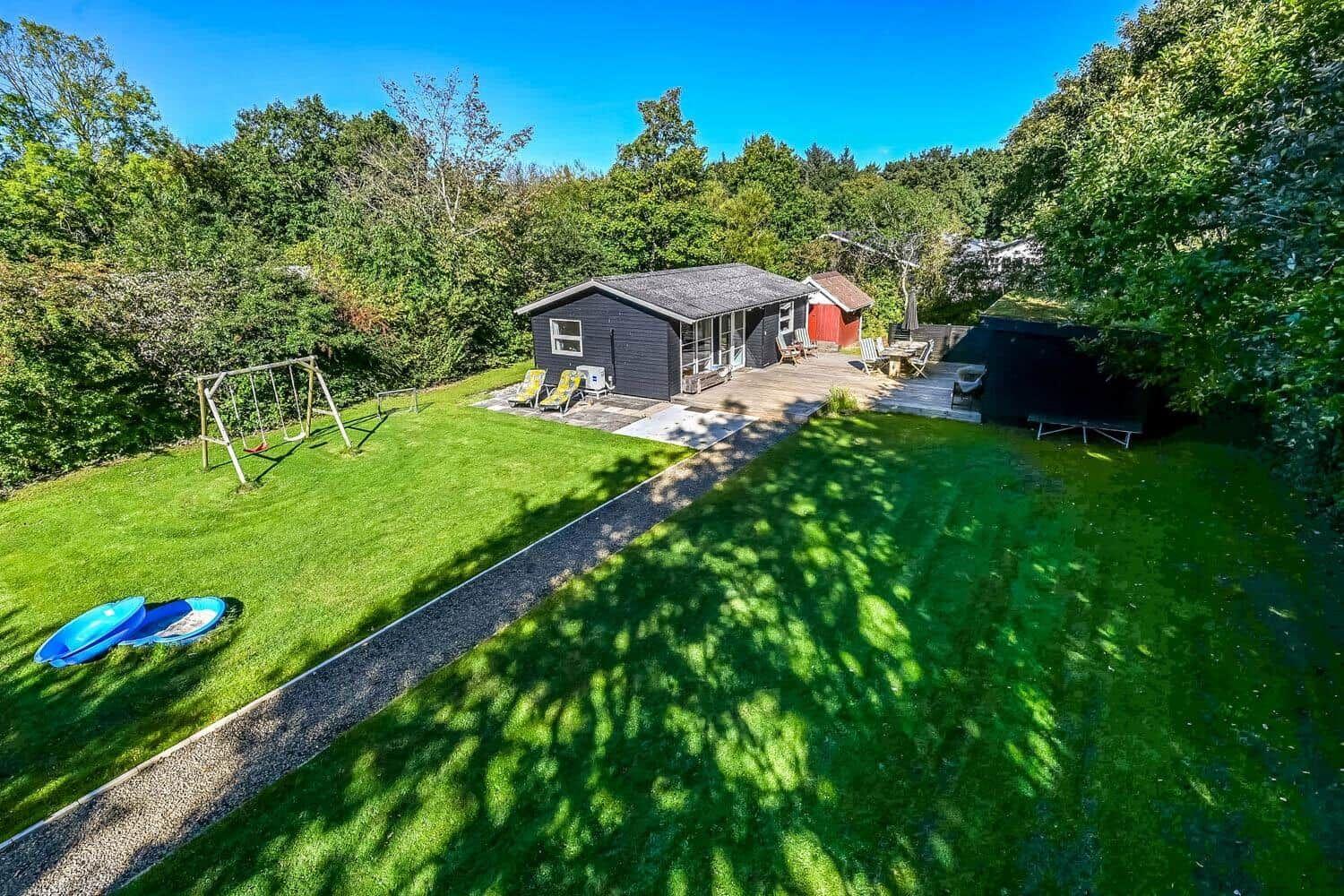 Two houses with garden, playground, and pool in greenery.