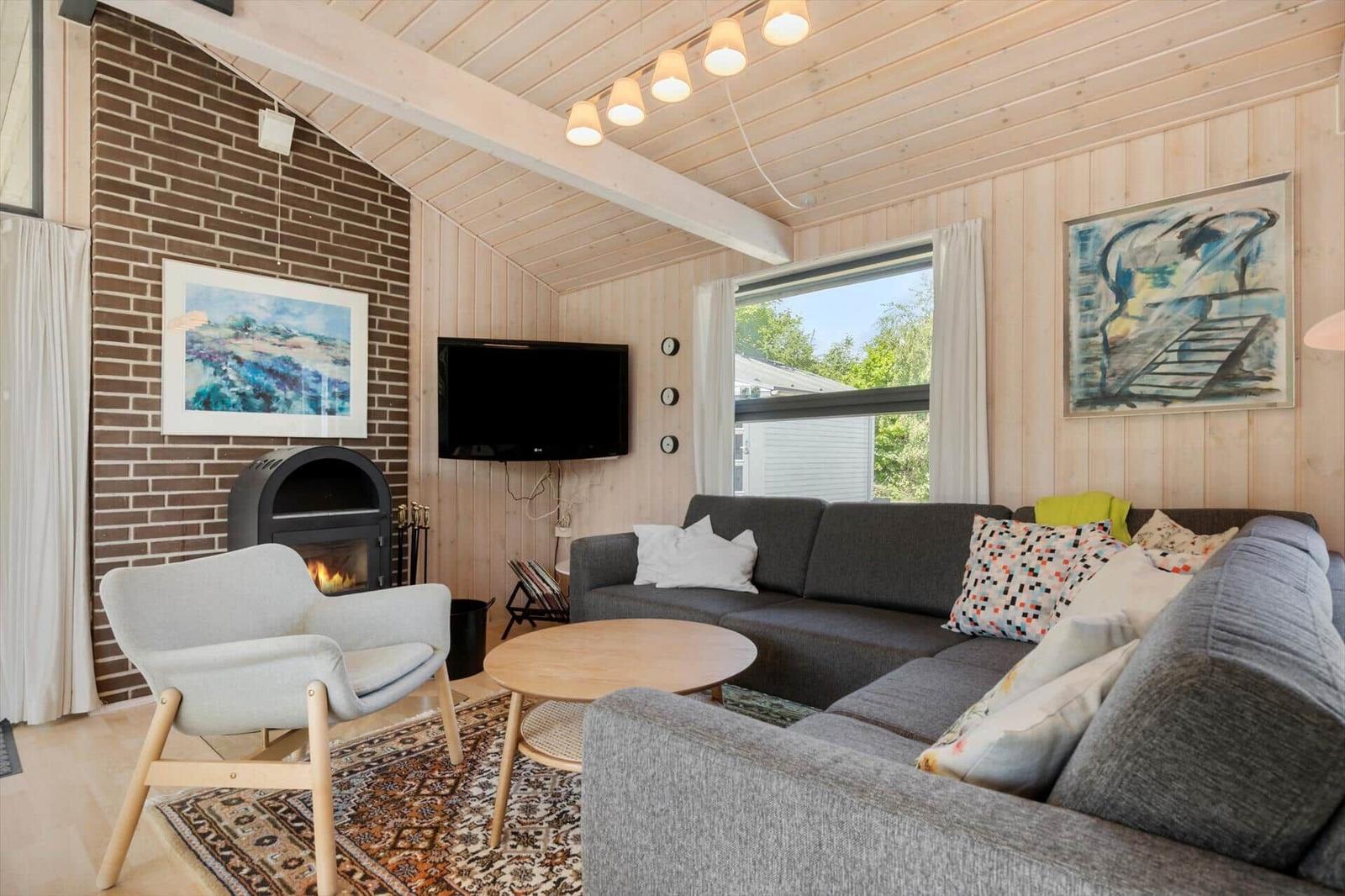 Living room with sofa, fireplace, and TV mounted on the wall.
