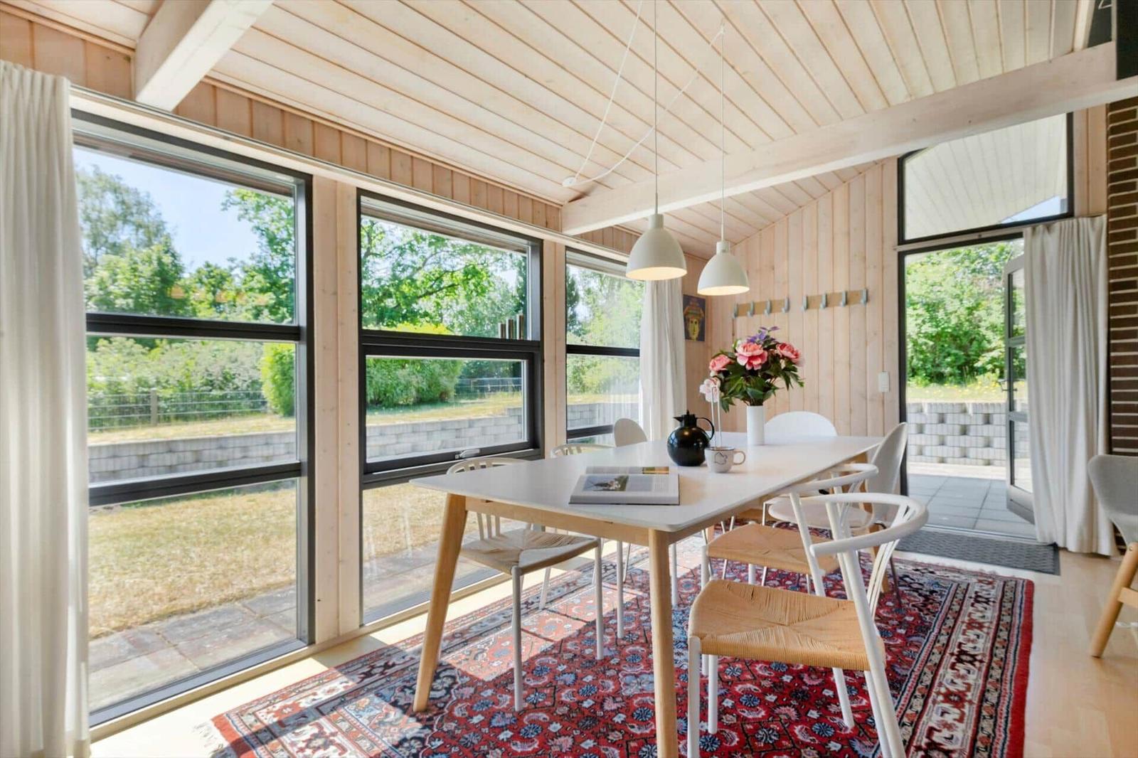 Dining room with table, chairs, and view of garden.