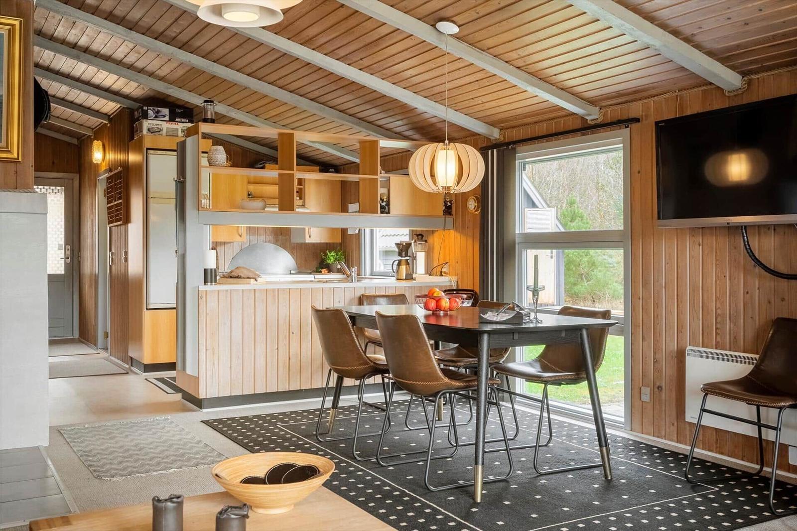 Küche mit Essbereich, Holzverkleidung und Fensterblick